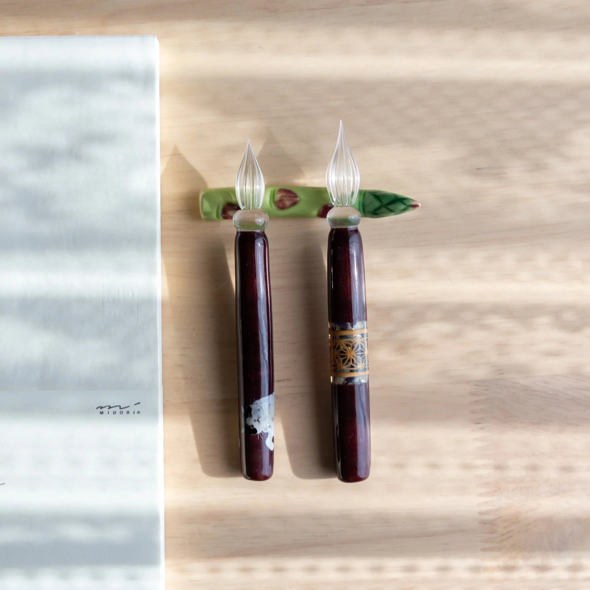 Forest green asparagus handcrafted pen rest showing bundled spear structure with functional pen slot on neutral surface