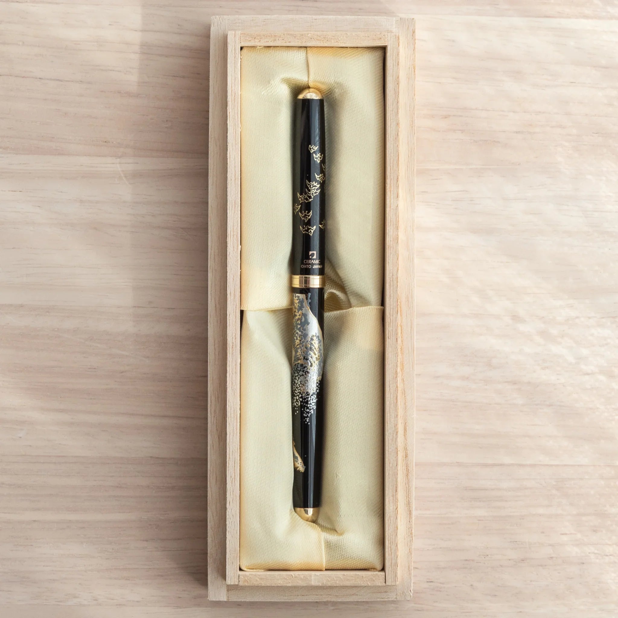 Maeju Yamanaka ballpoint pen with Great Wave silkscreen in open natural wood gift box with gold fabric lining, overhead view