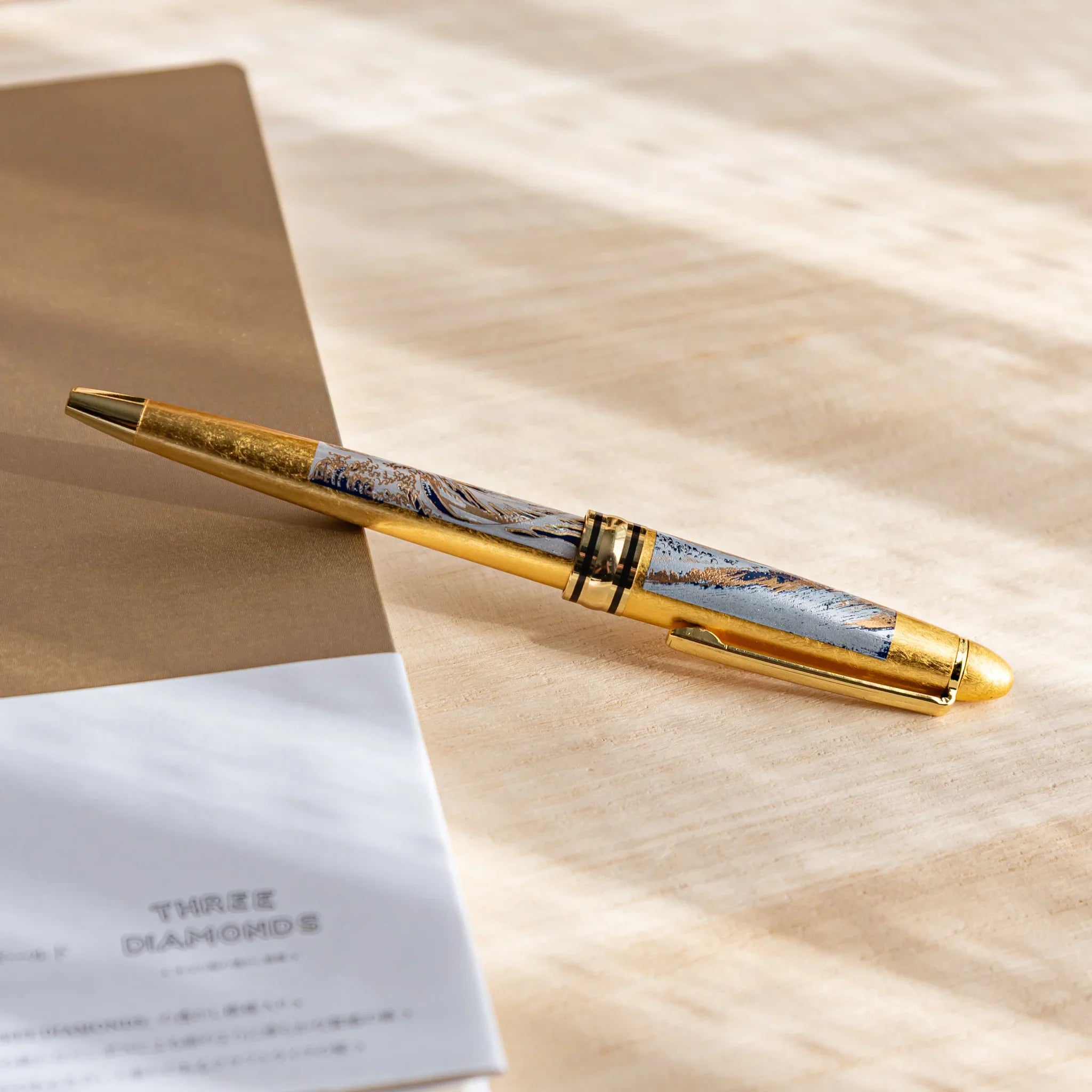Pen barrel showing Great Wave landscape artwork with gold leaf application detail and composition in composition