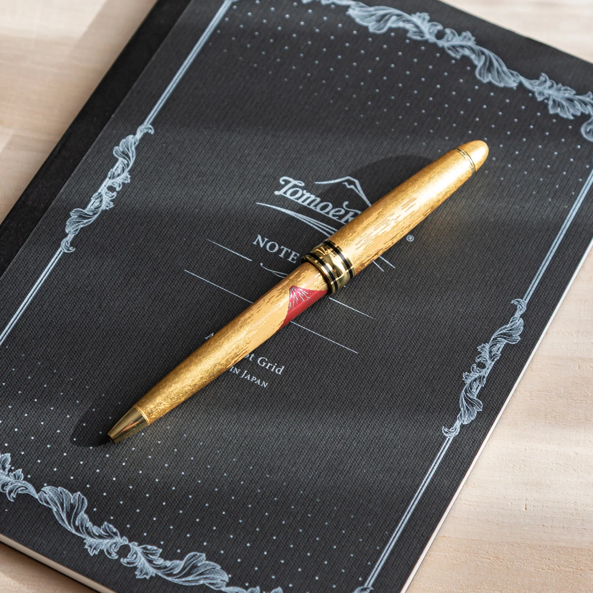 Retractable ballpoint with Mt. Fuji motif and ornate gold leaf design composition shown with gold trim accents