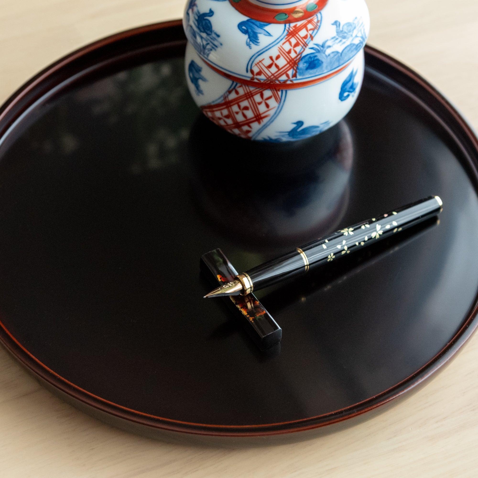 Japanese Echizen black lacquer pen rest made from sakura wood with precious gold foil inlay, keeping pens secure during