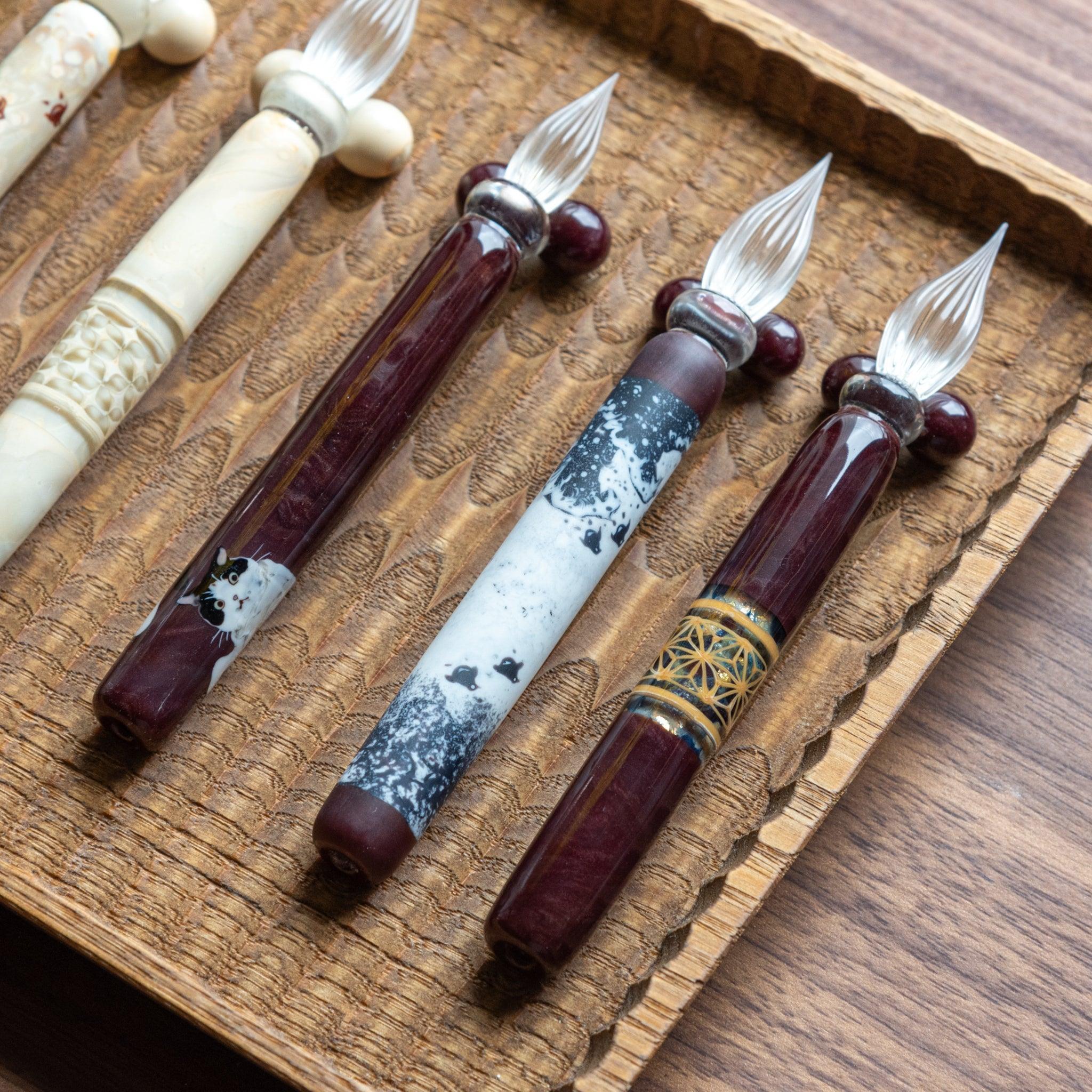 Angled view of Great Wave chidori glass dip pen revealing layered wave and bird pattern design in glass barrel