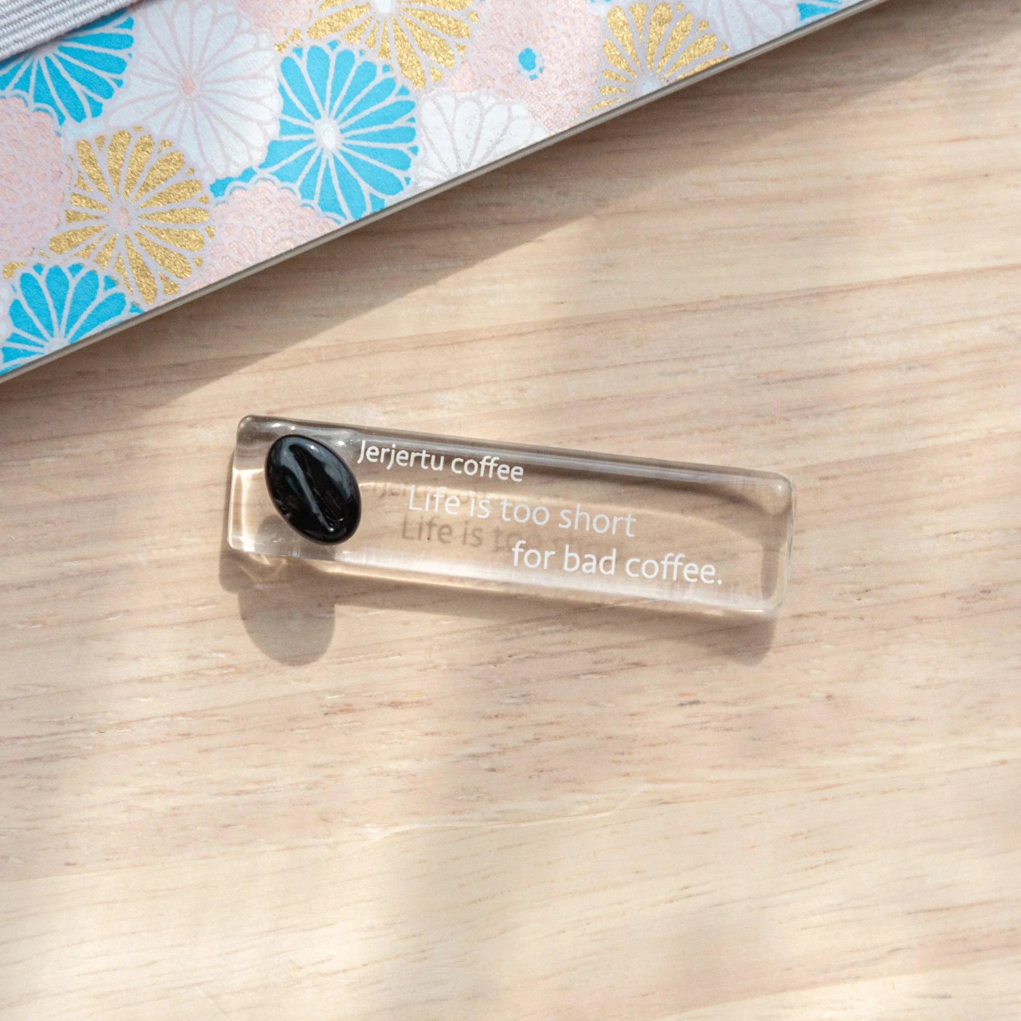 Coffee Bean Glass Pen Rest displayed with brown coffee bean motif etched throughout the transparent glass rest shape