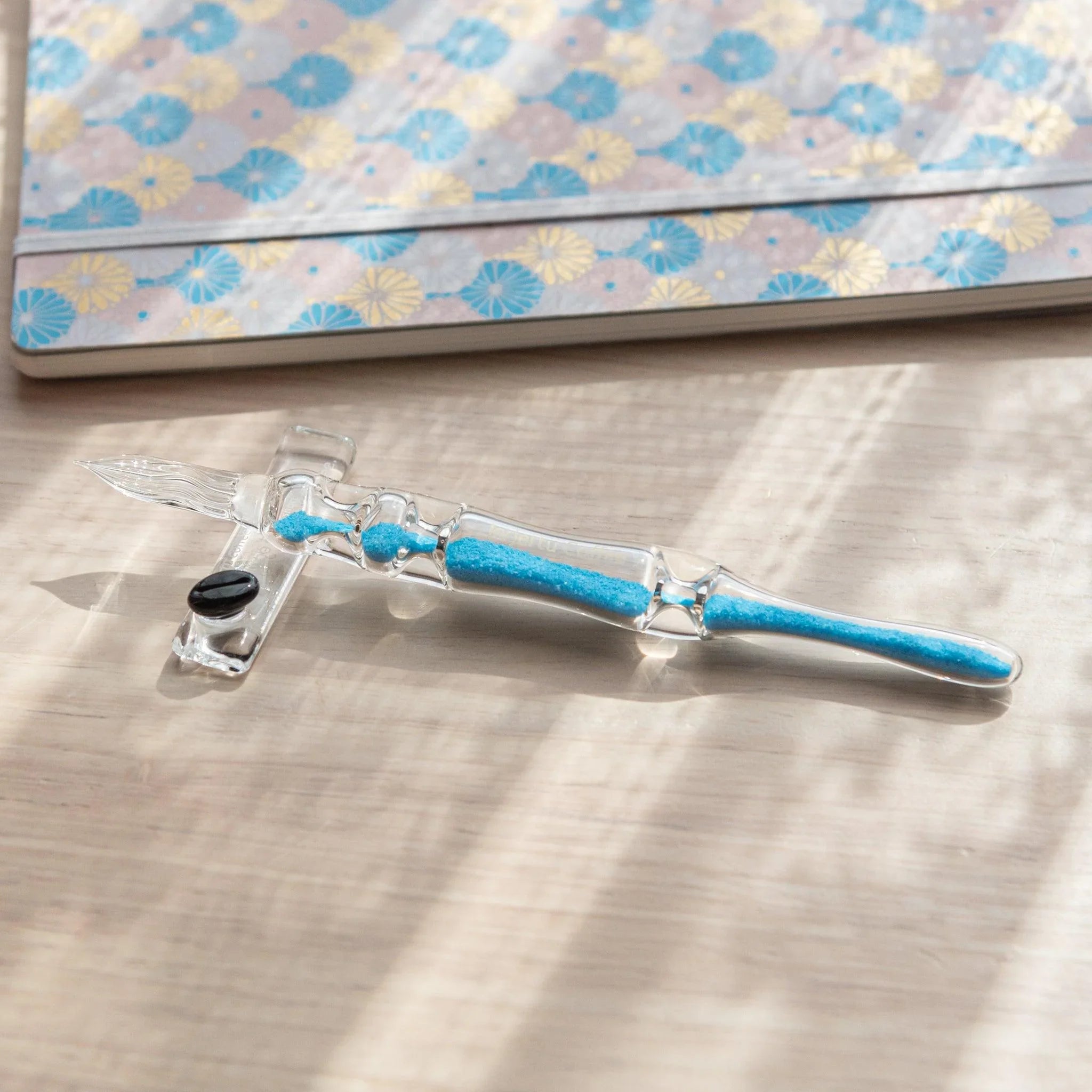 Cote d'Azur Hourglass Glass Dip Pen detail of nested glass chambers with turquoise color gradation and light reflection