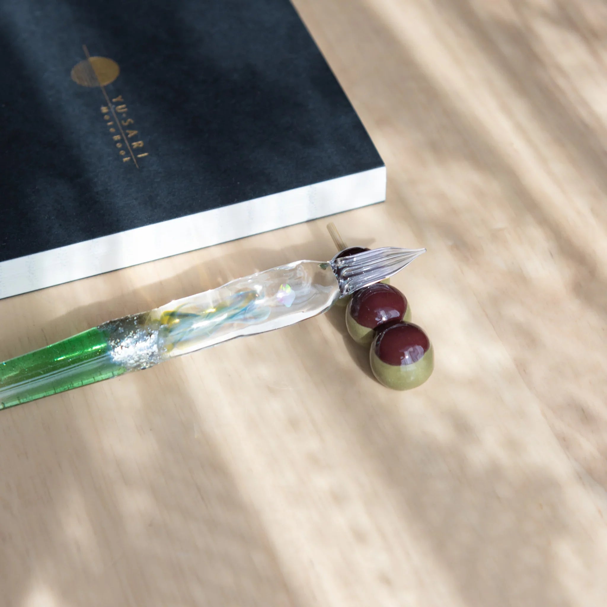 Brown and cream dango handcrafted pen rest with three stacked beads and natural wood stick base construction detail
