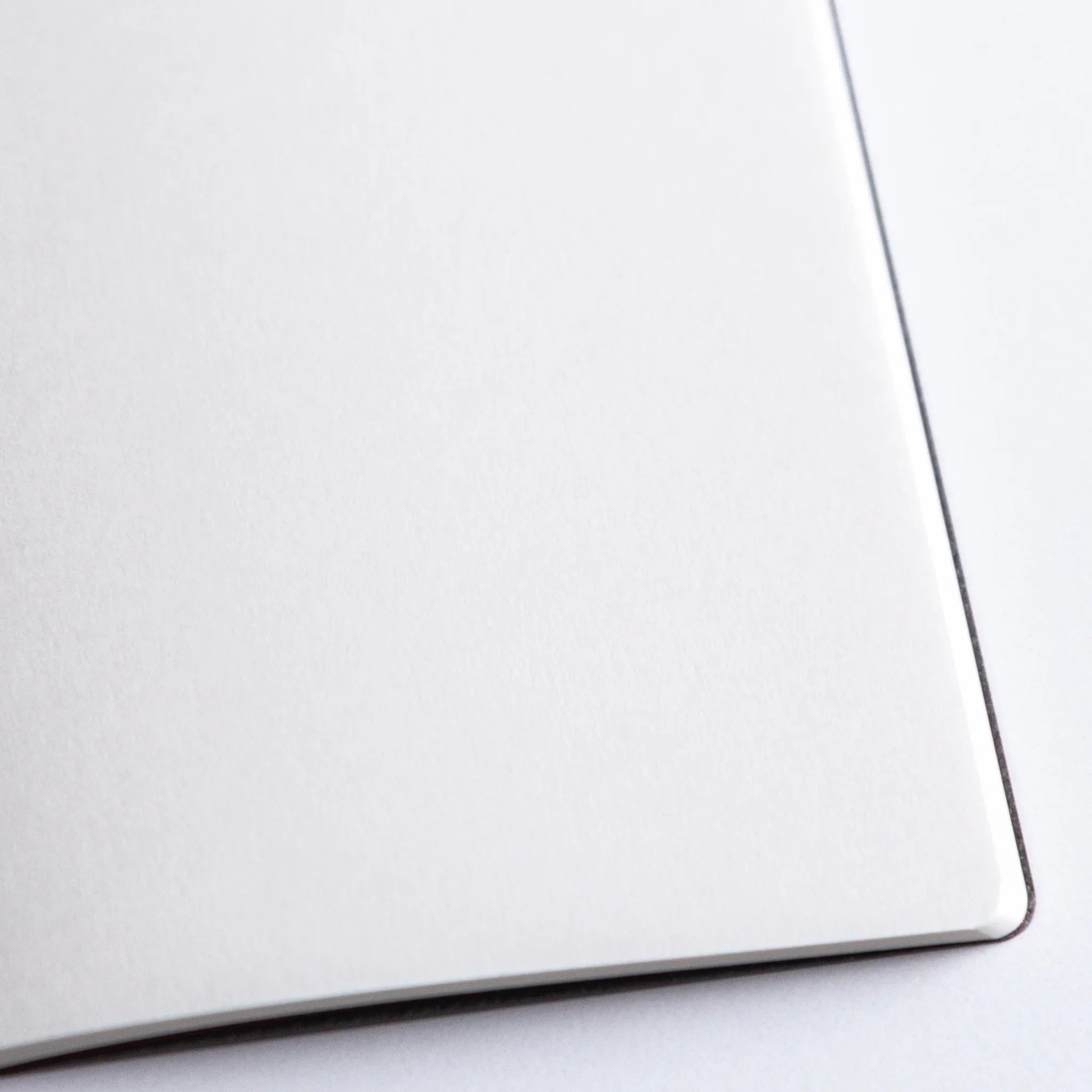 Dressco A6 notebook with partially opened pages displaying ledger horizontal ruling throughout interior page surfaces