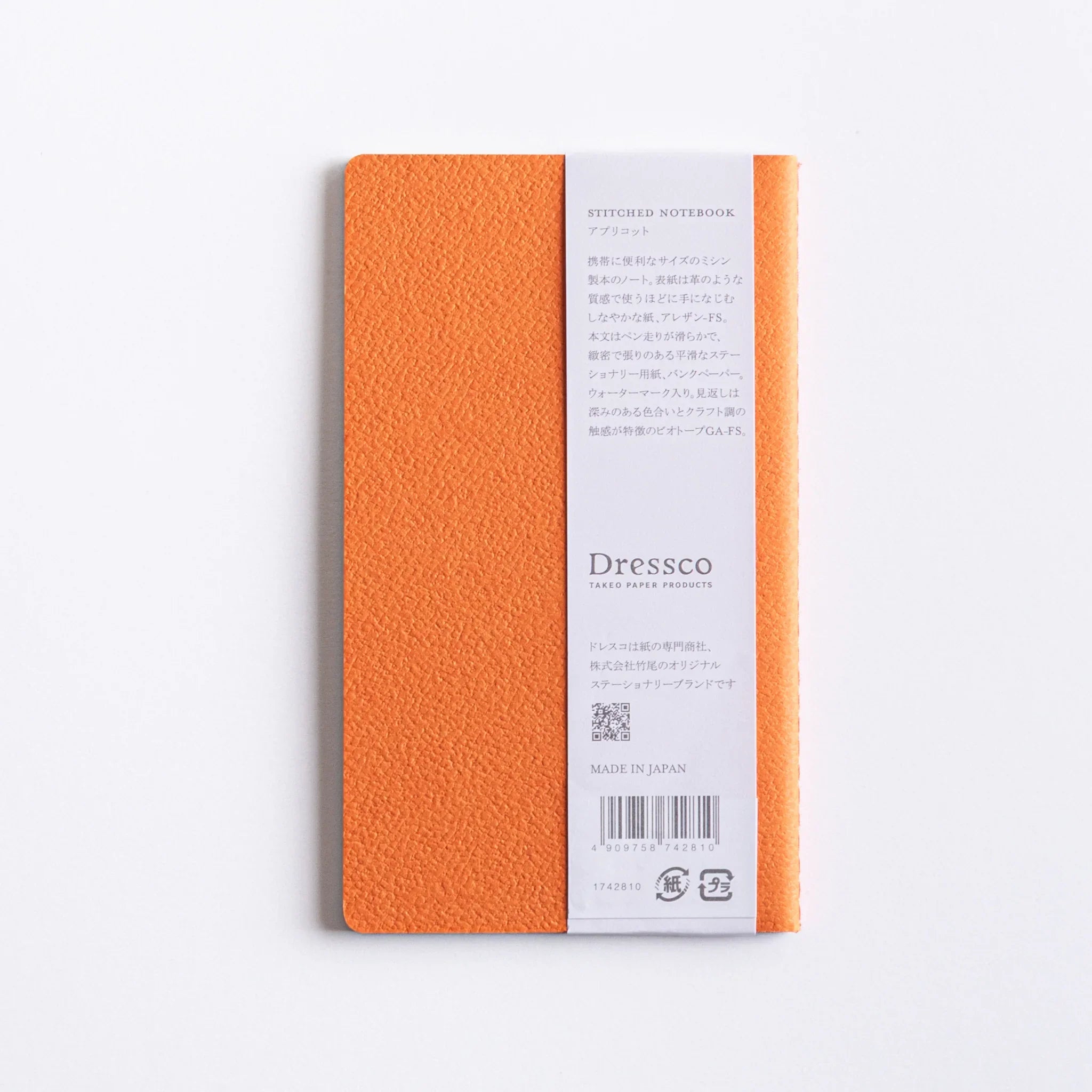 Back cover of charcoal Dressco A6 notebook showing embossed bird logo and detailed product information text printed