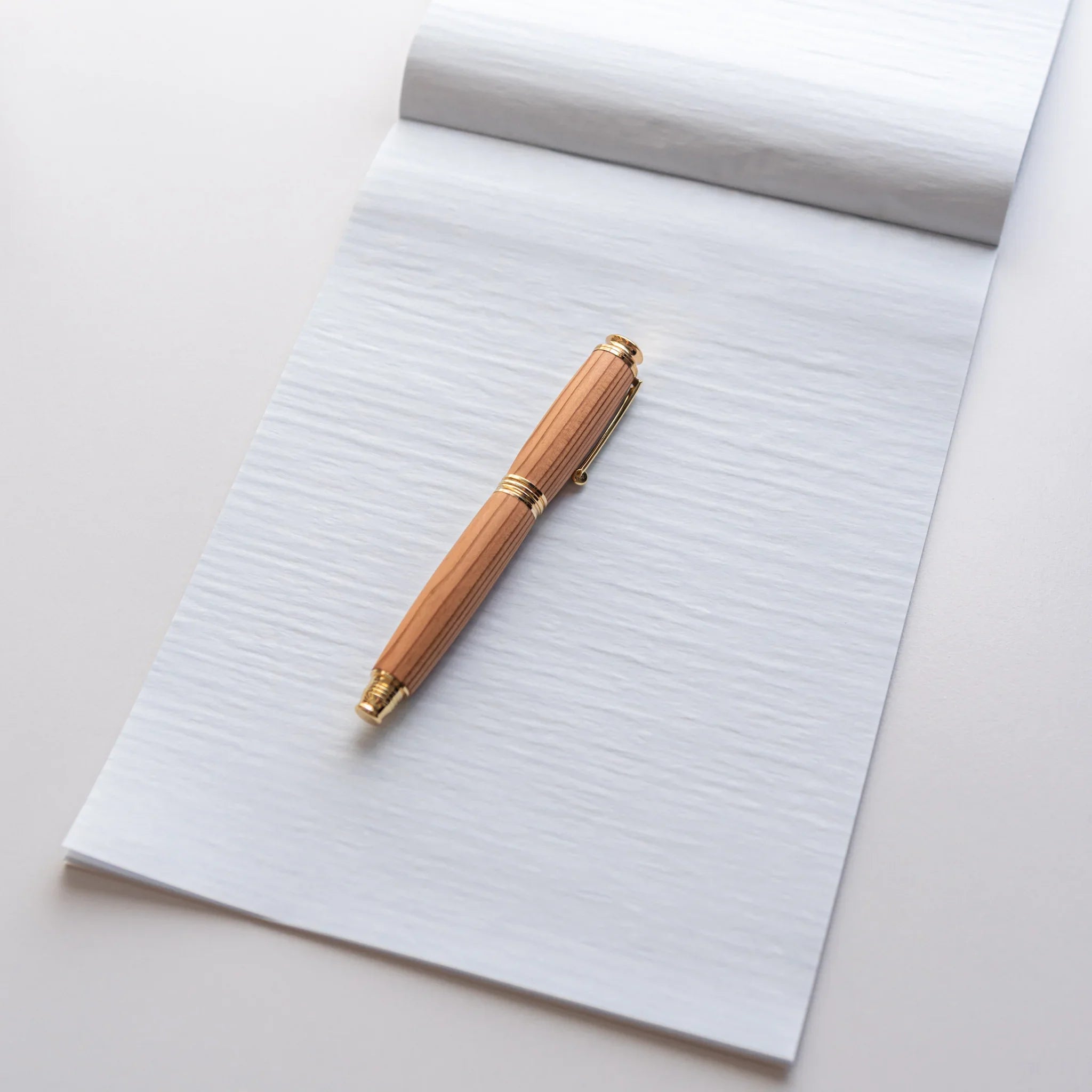 Writing pad displayed standing showing side profile and binding construction showing product quality and design details