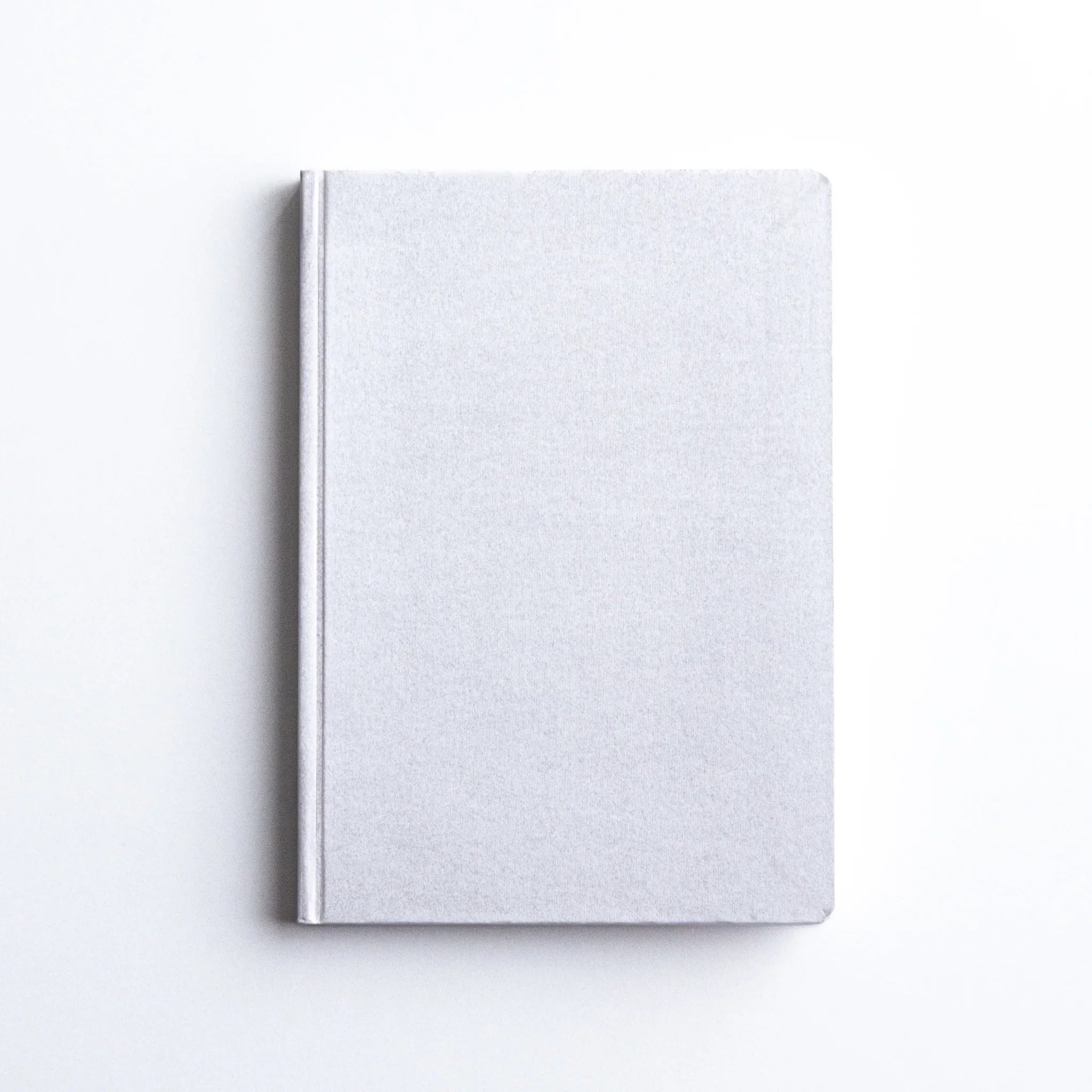 Dressco Spica Laid Bond Paper A6 notebook placed face-up in a flat composition showing cover from front angle