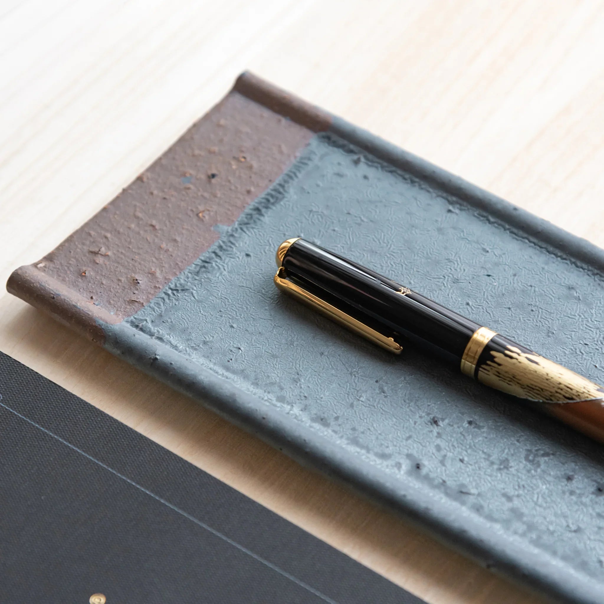 Echizen Kawara silver gray ceramic pen tray with four slots shown in composition displayed in composition