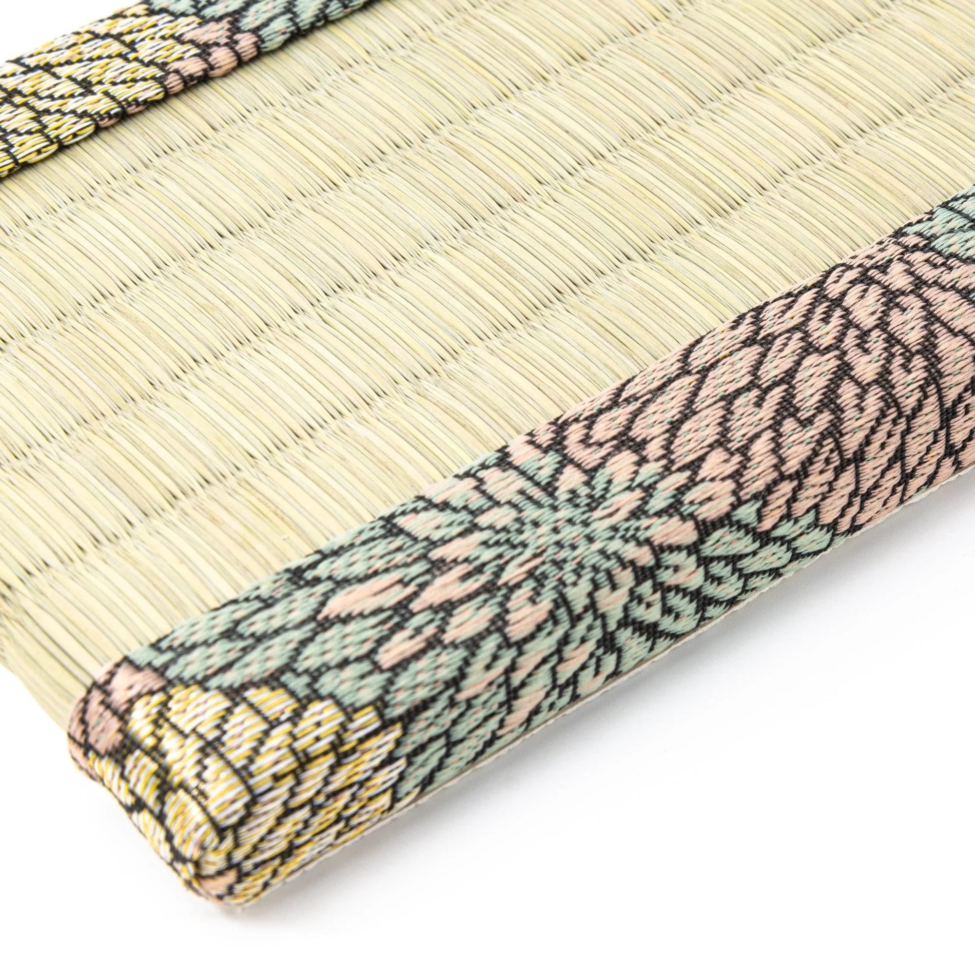 Close-up of Chrysanthemum Tatami Pen Tray corner showing pink teal and gold floral brocade border wrapped around tatami edge