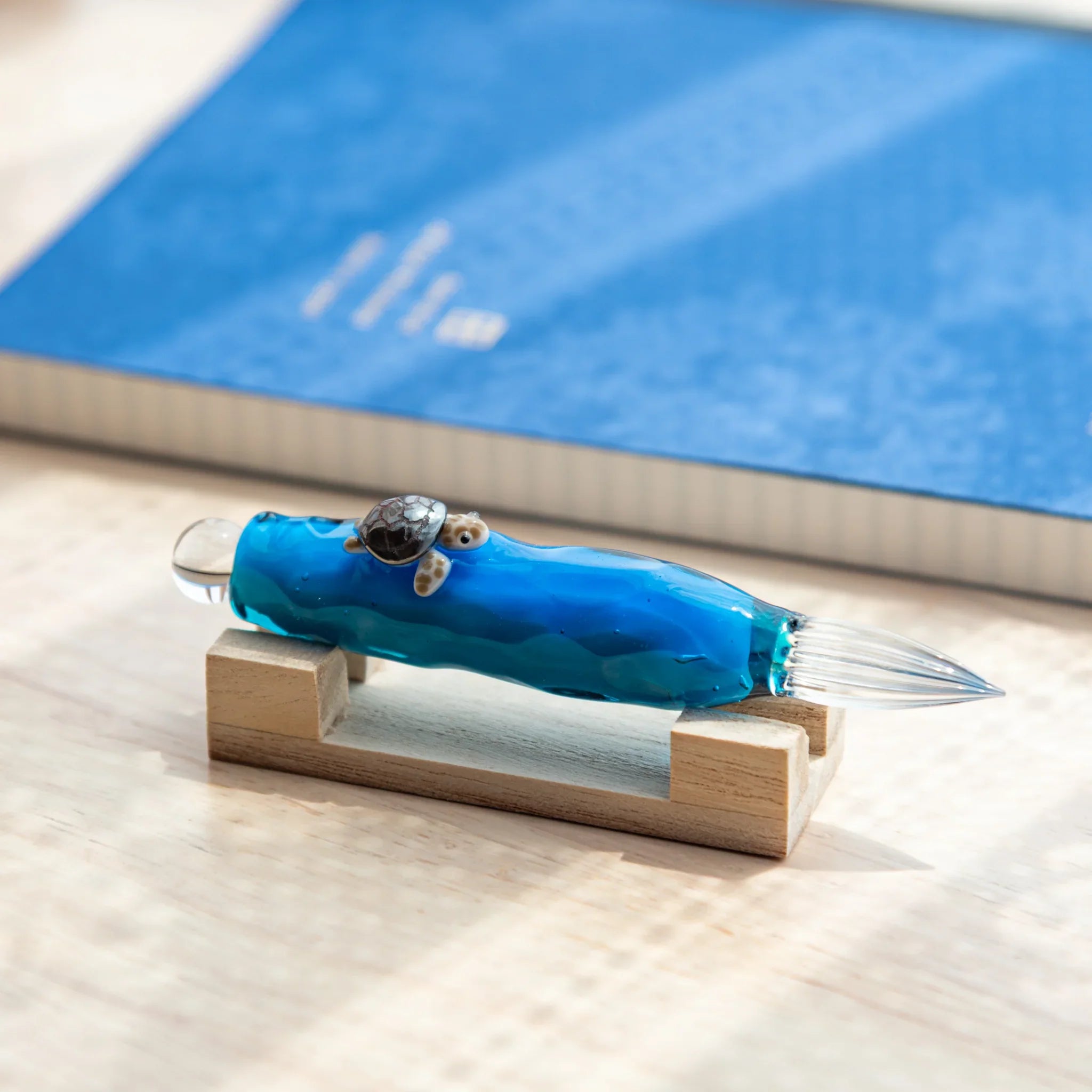 Sea turtle glass dip pen with floating decorative figure inside clear barrel, showing hand-made detail