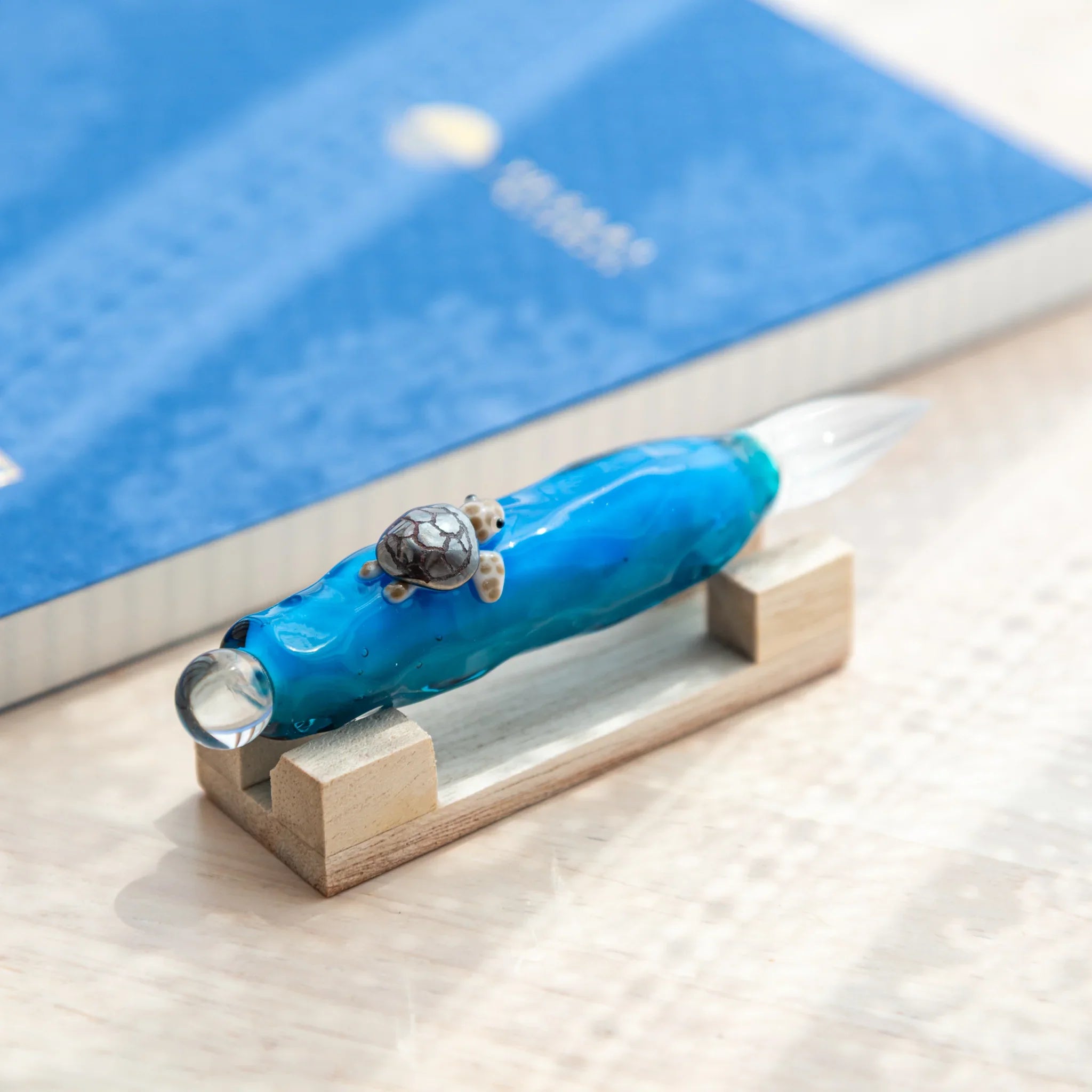 Glass dip pen with sea turtle floating inside transparent barrel, showing intricate enclosed design and craftsmanship