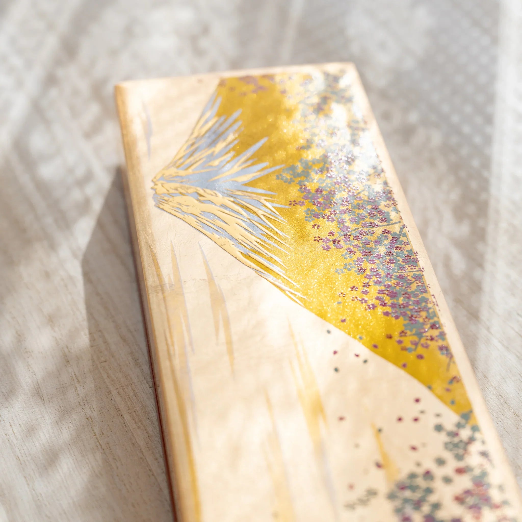 Yamanaka case detail with Mt. Fuji peak and traditional sakura flower pattern composition clearly shown