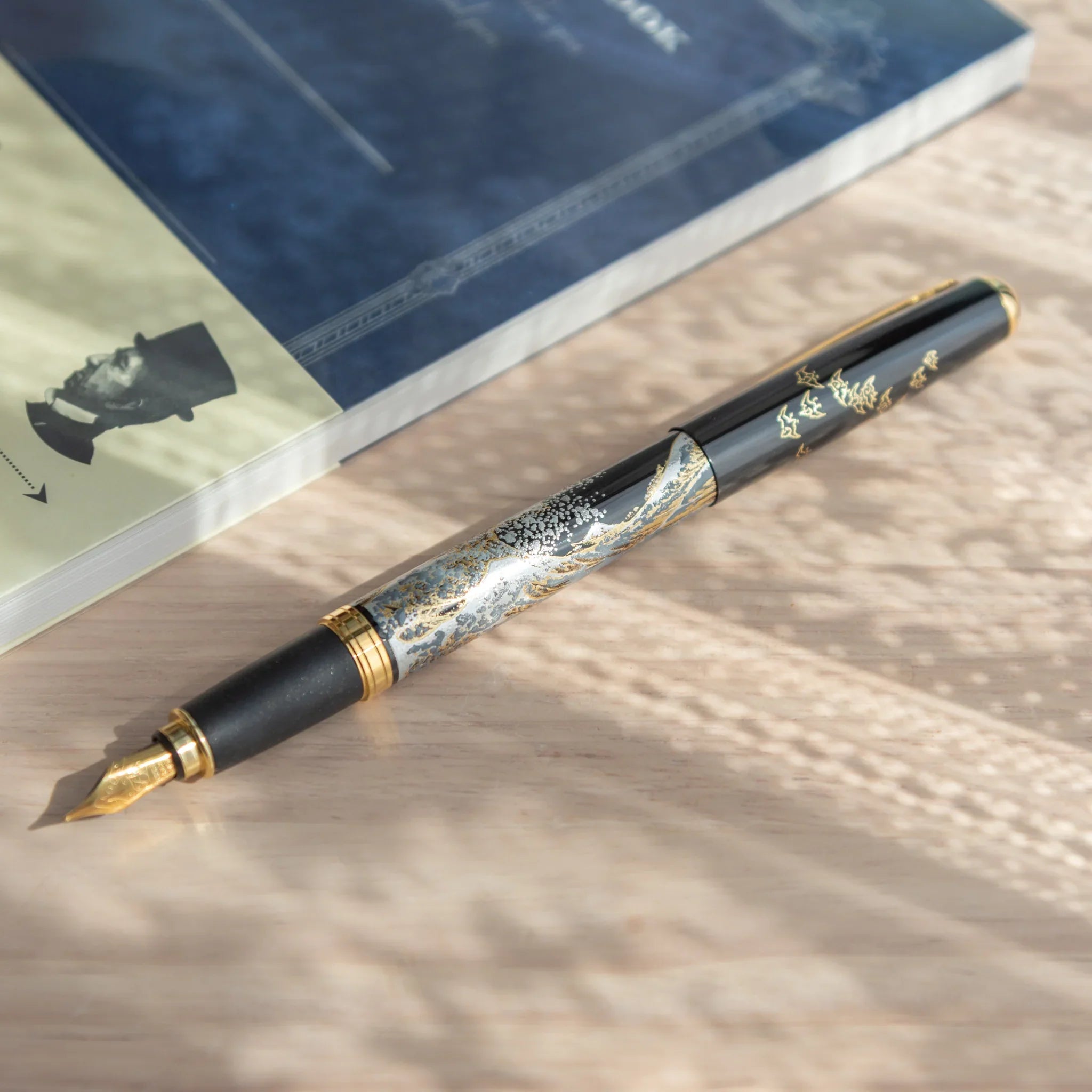 Yamanaka lacquer fountain pen displays hand-painted Great Wave seascape in classic blue lacquer finish