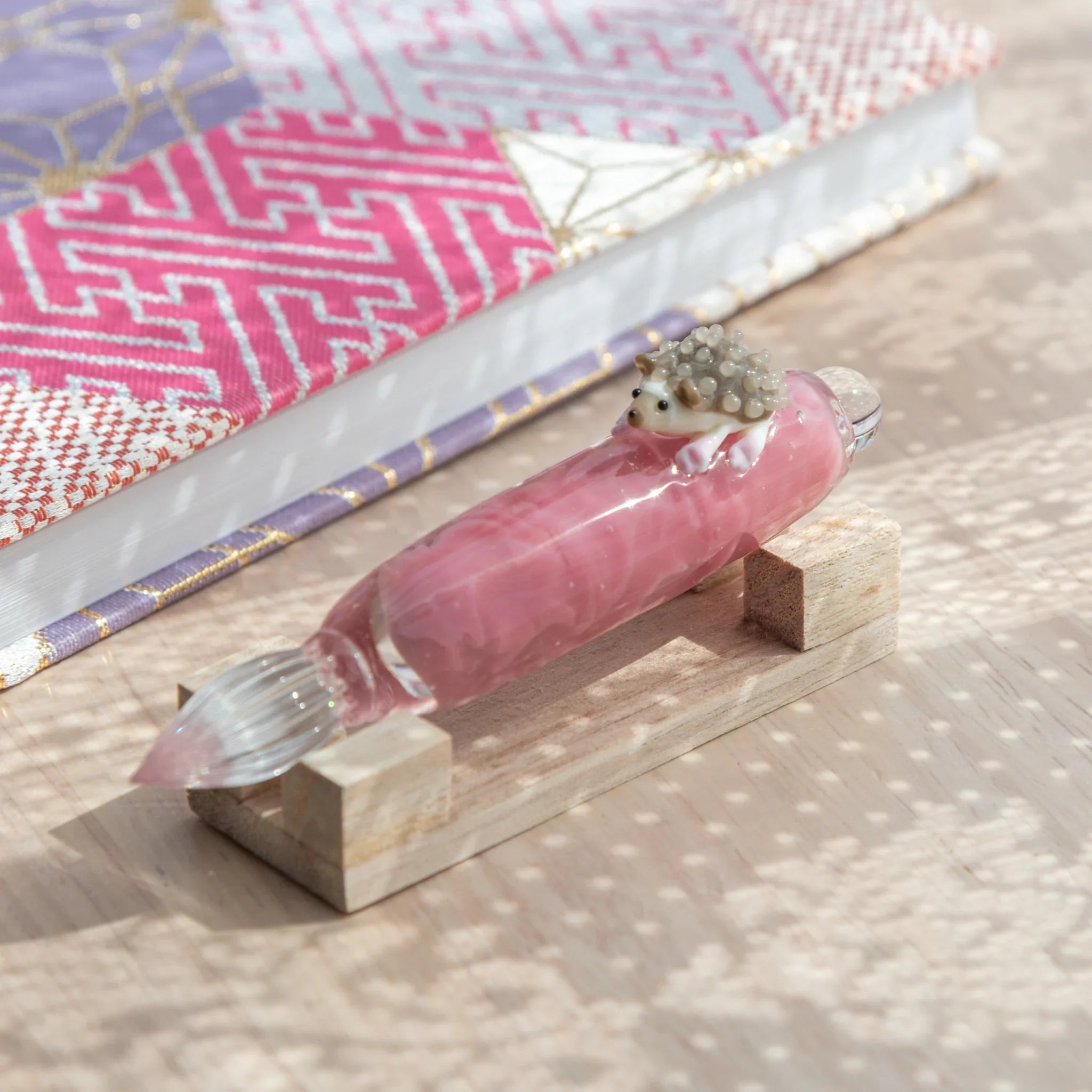 Adorable hedgehog glass dip pen with cute spiky creature perched on colored hand-blown glass ink bottle