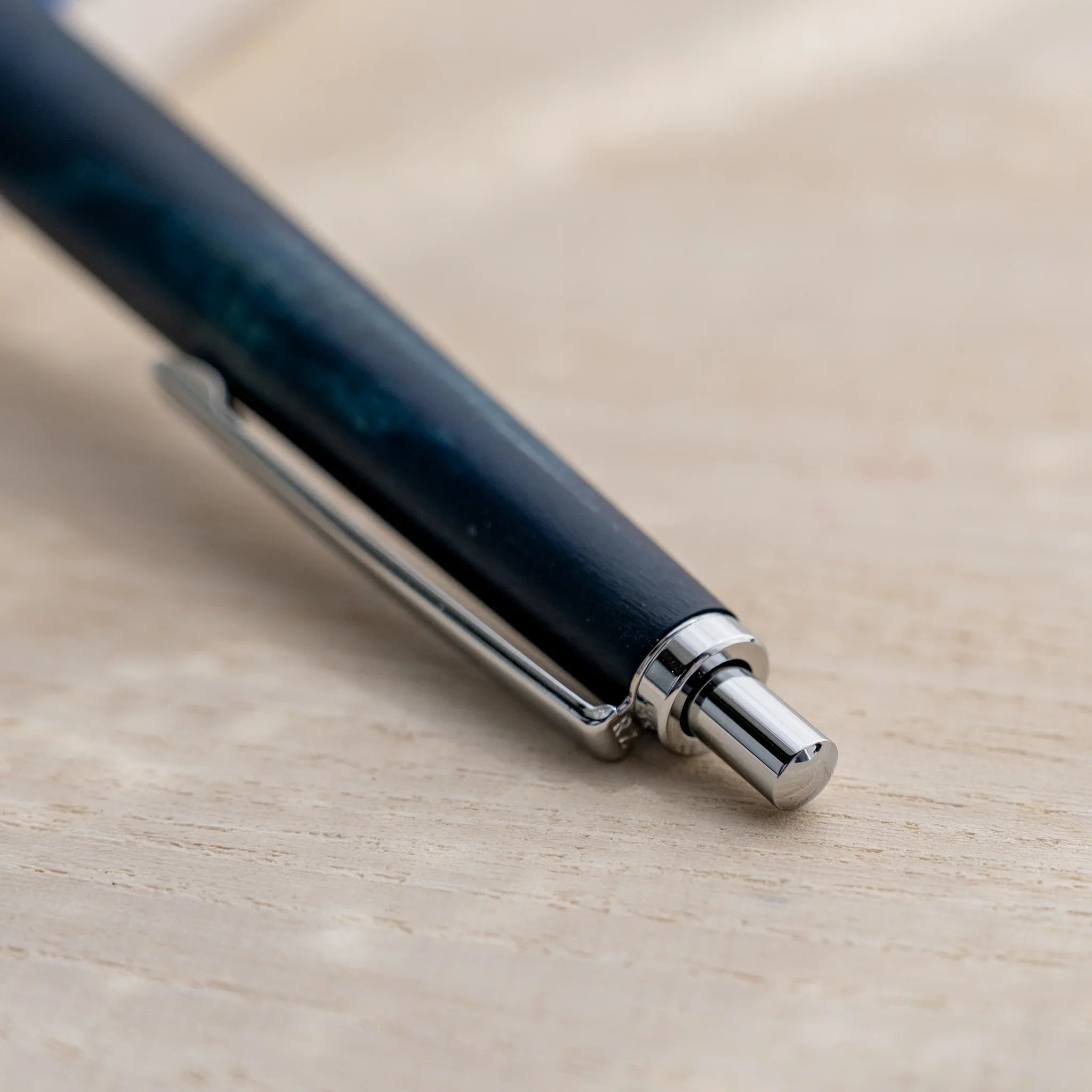 Indigo blue horse chestnut wood urushi ballpoint pen, close-up of silver knock button and clip, Japanese wood