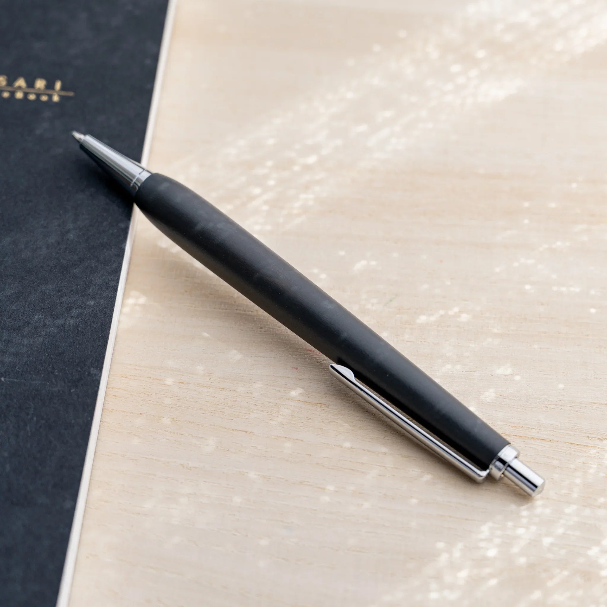 Horse chestnut wood urushi lacquered ballpoint pen in charcoal black, Japanese wood, angled full-body view