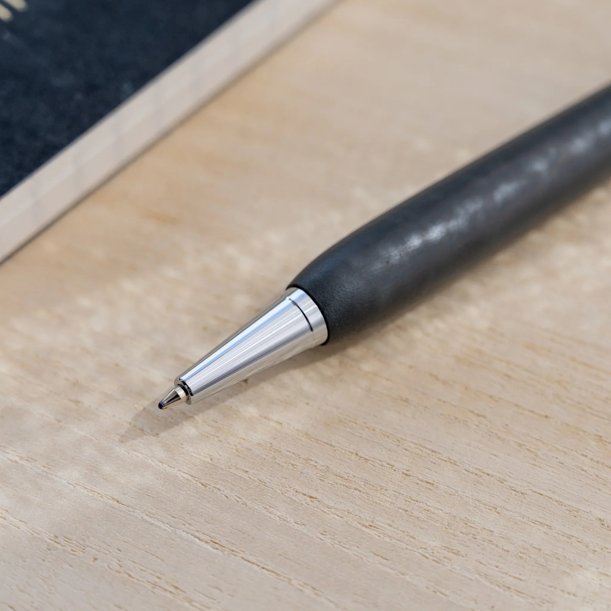 Charcoal black horse chestnut wood urushi ballpoint pen, close-up of barrel and silver clip, Japanese wood