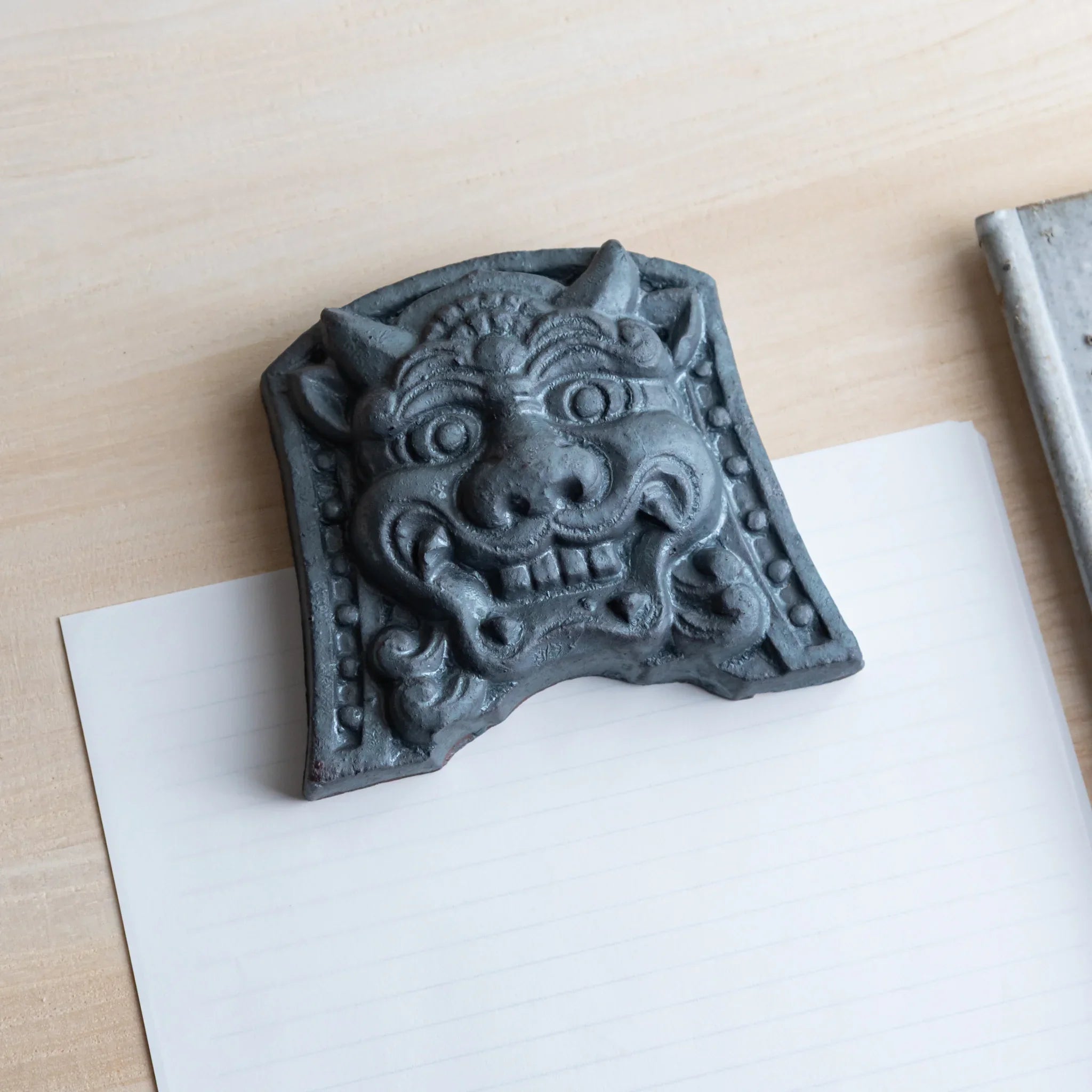 Japanese Kawara large roof guardian ceramic paperweight with resolute expression shown in detailed composition