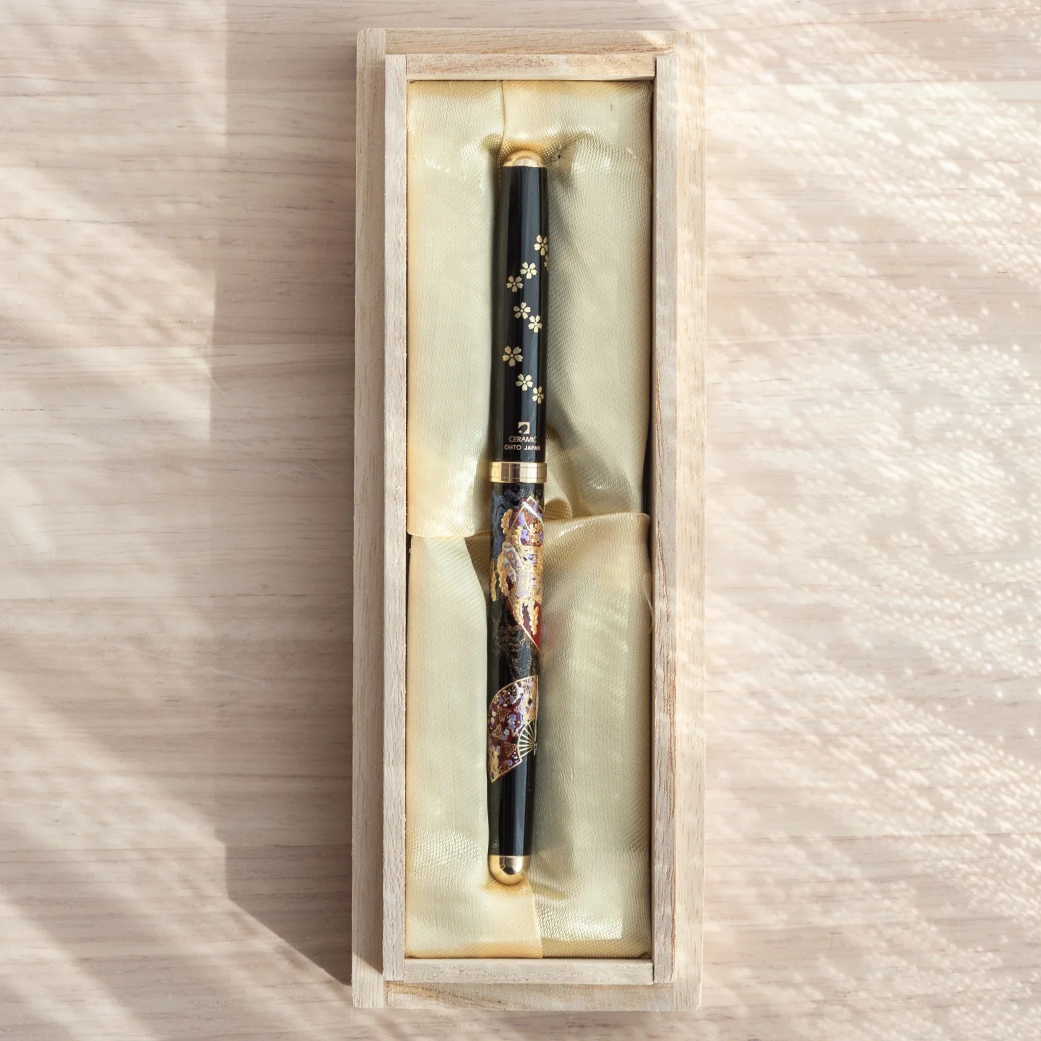 Kyoto Elegance Yamanaka Japanese ballpoint pen in open paulownia wood gift box with cream satin lining, overhead view