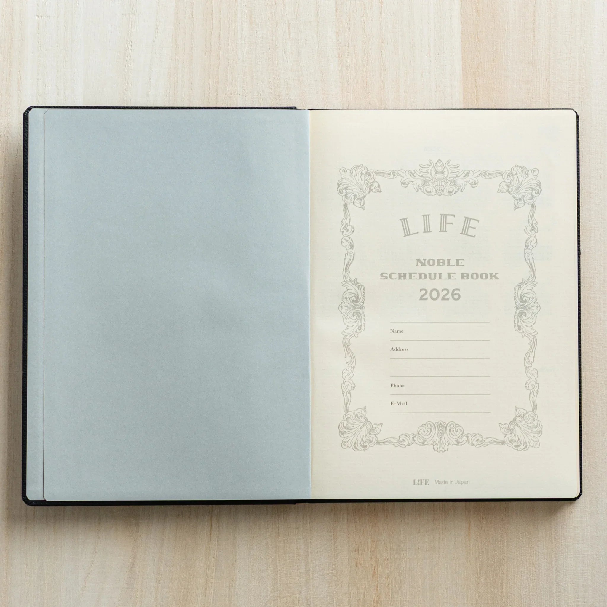 Life Noble 2026 planning notebook, navy leather cover, open showing pages highlighting gold lettering