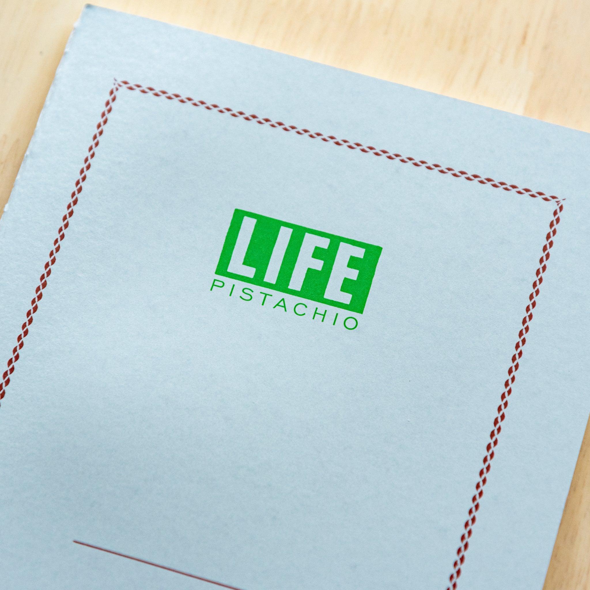 LIFE Pistachio-colored A5 notebook with soft green hue, angled shot of thick binding and quality cover material