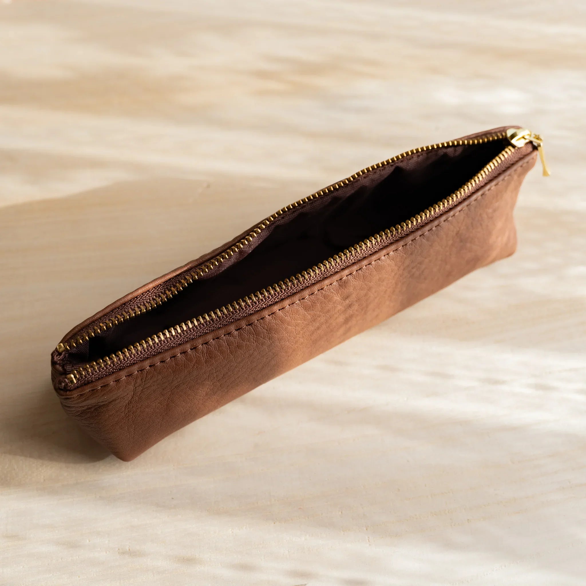 Zipper mechanism displayed showing gold hardware on brown case and features and features and features