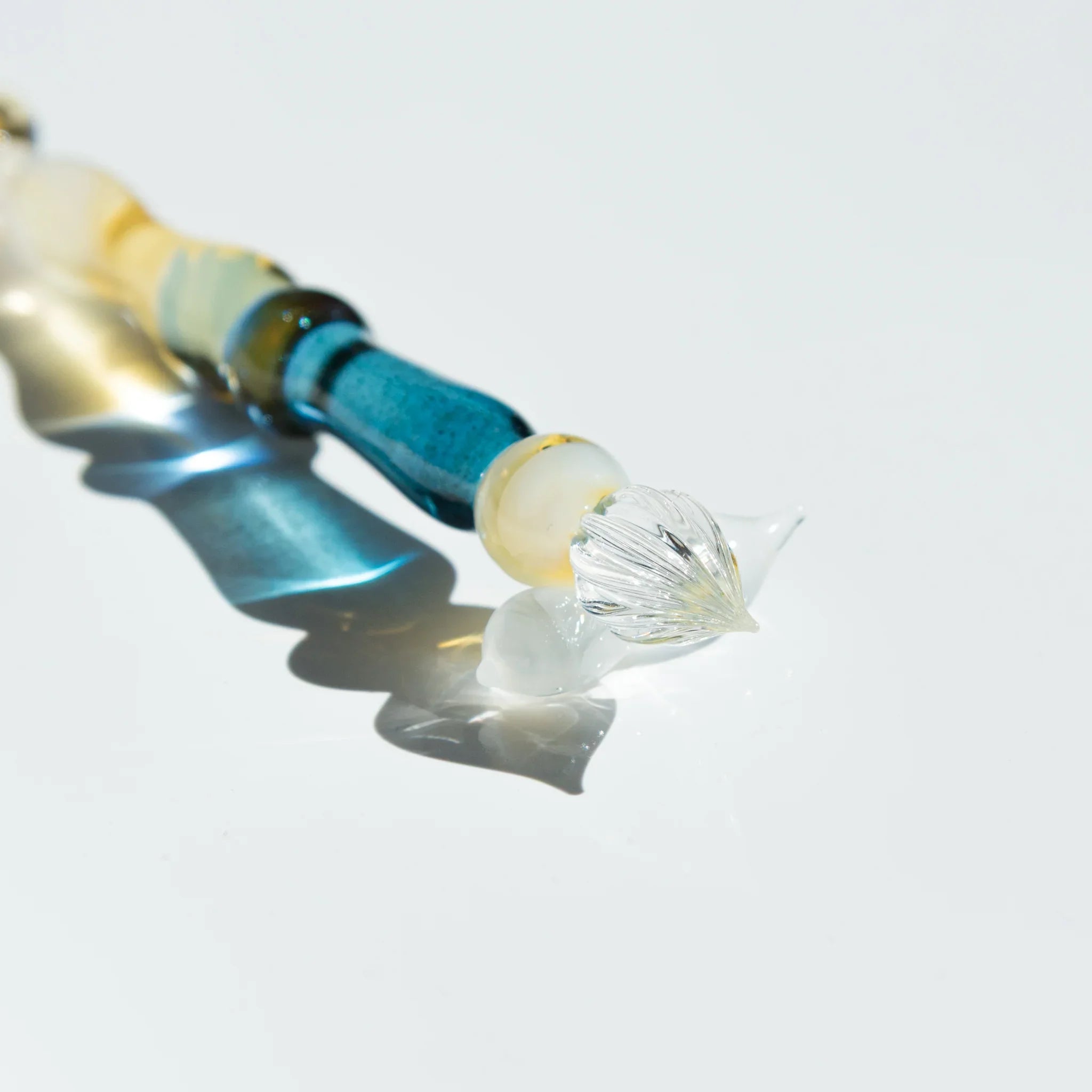 Lunar Glow glass dip pen displaying opalescent iridescent finish with turquoise wrapped handle and moon rest shine
