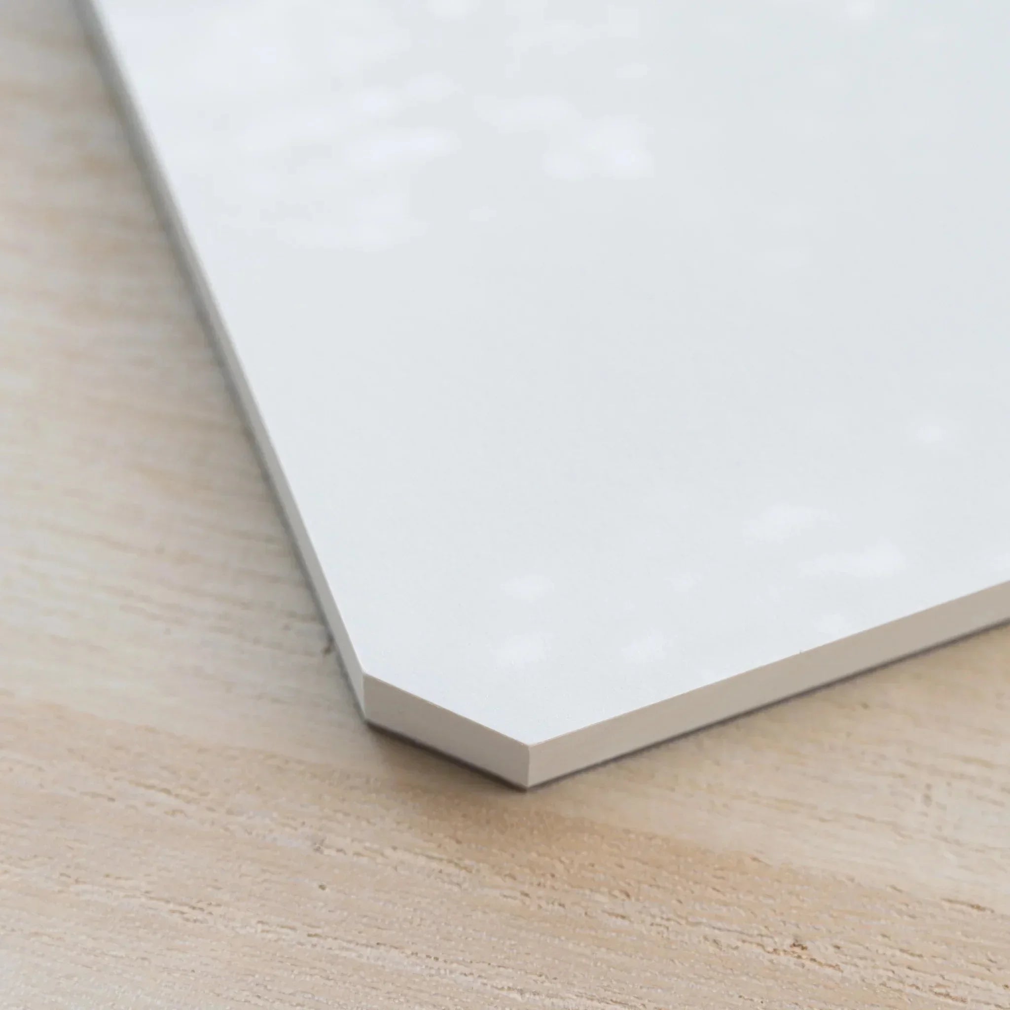 Close-up of the angled cut corner of a Midori MD Paper Pad Cotton A5 with page block on a gray backing board
