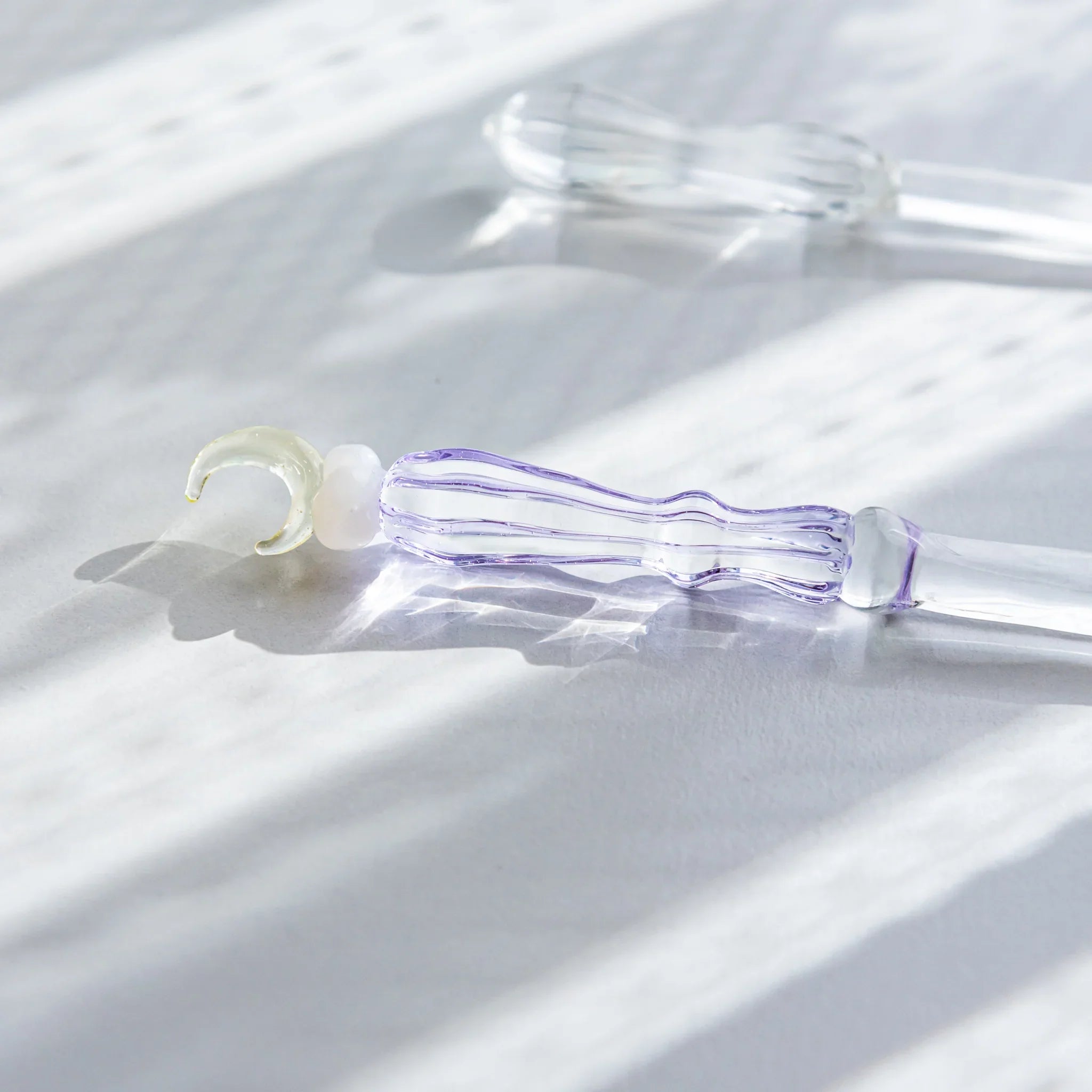 Moonlit cloud glass letter opener with lavender tint shown in composition shown view composition product composition view
