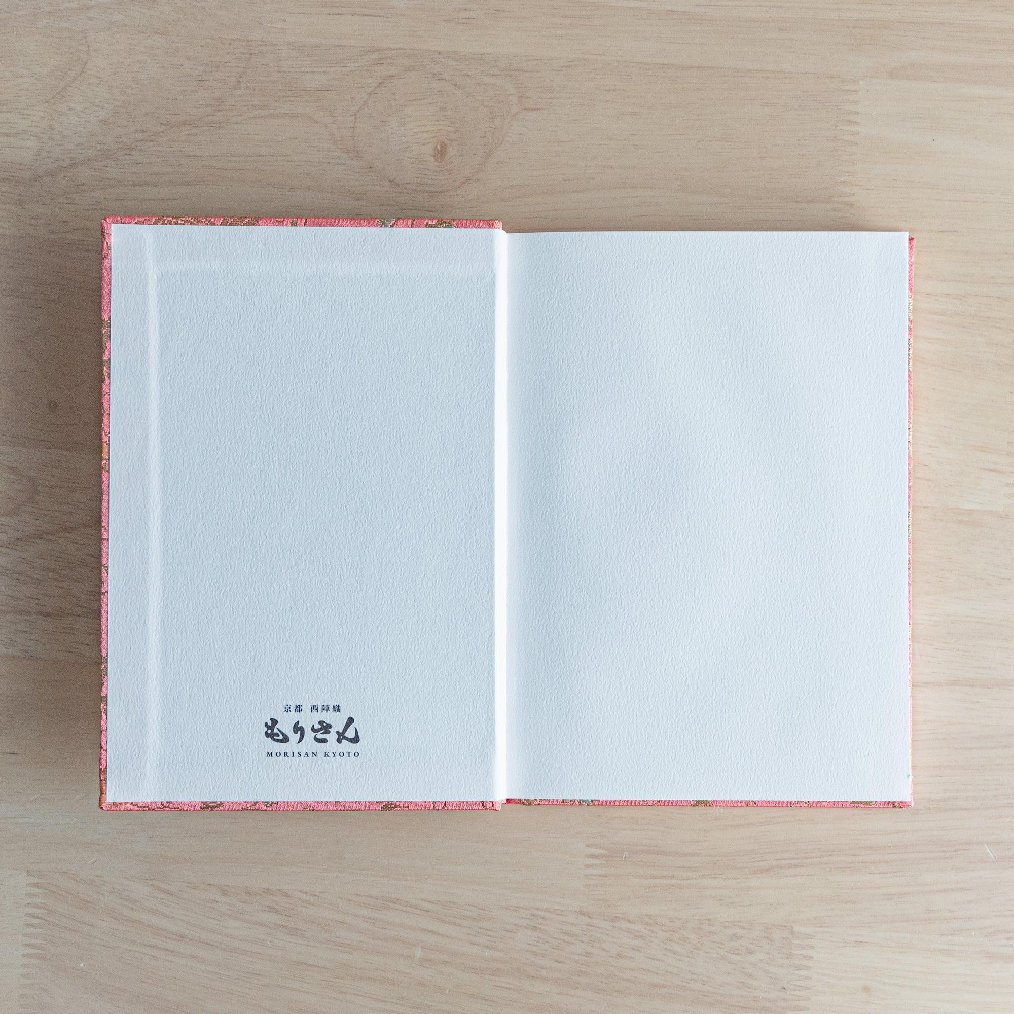 Opened Nishijin textile Japanese notebook with white endpaper and Morisan Kyoto branding on left and blank white right page