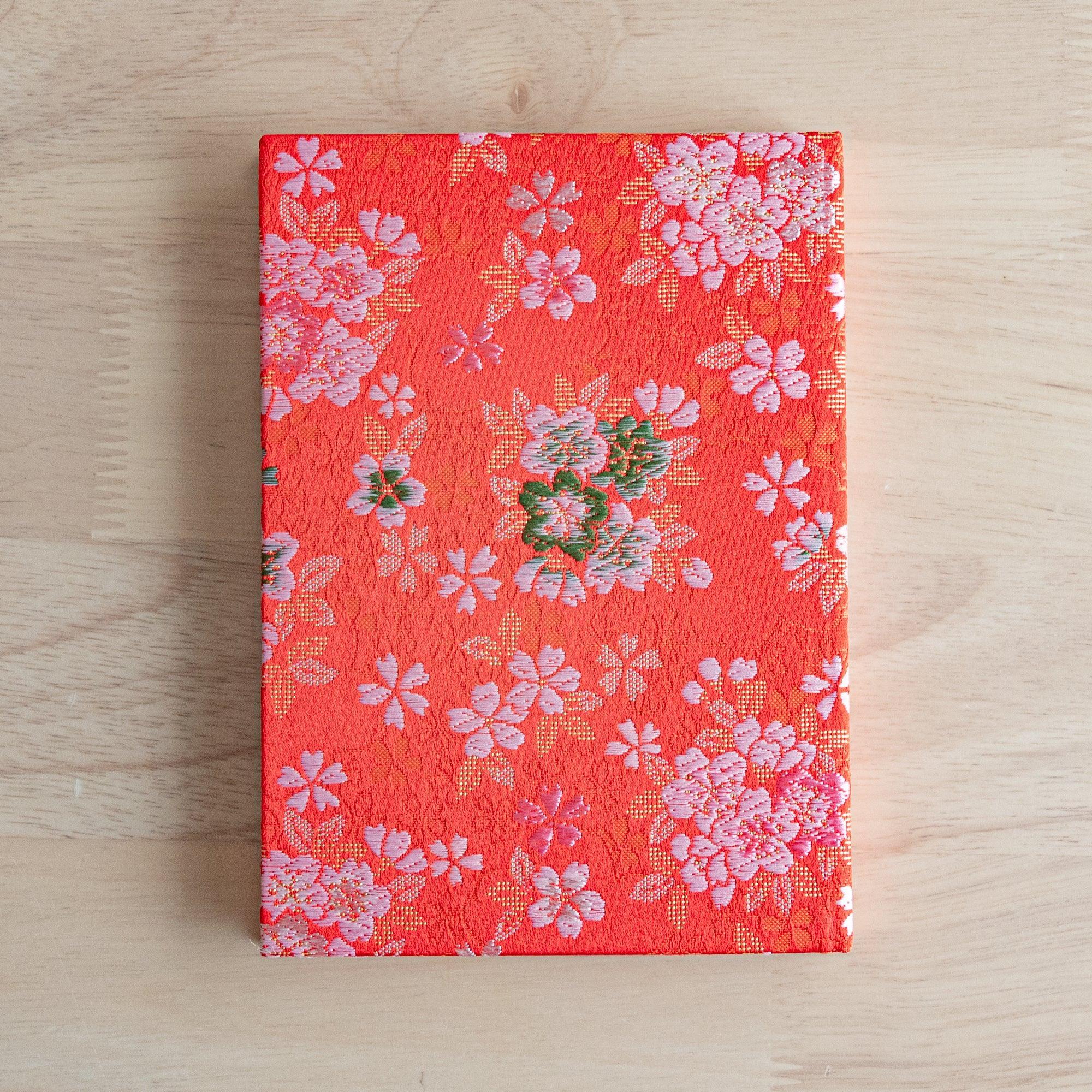 Nishijin textile B6 notebook, flat lay of traditional Sakura Ensemble brocade design detail with binding