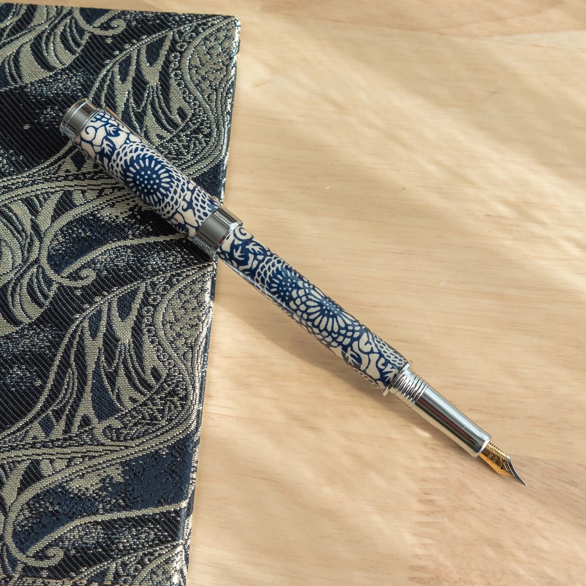 Peony Mino Washi fountain pen detail view displaying white peony blossom botanical pattern on navy blue Mino washi wrapper