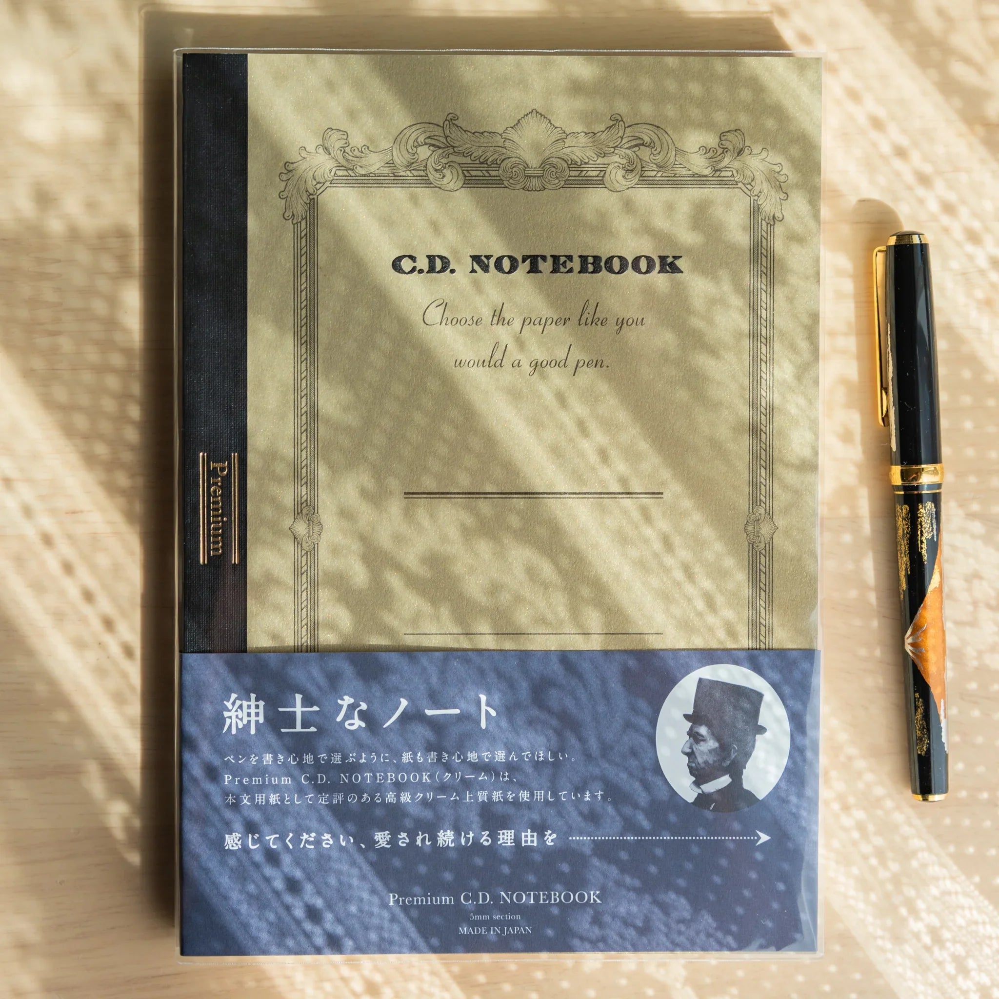 Premium CD A5 fountain pen notebook cream cover displayed open showing blue-tinted interior pages with quality line ruling