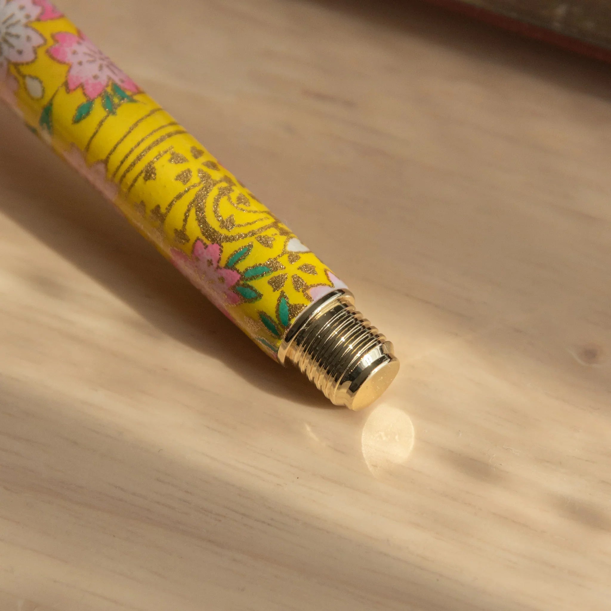Full-length Sakura and Canola Mino Washi fountain pen displayed horizontally with pink and yellow design with nib