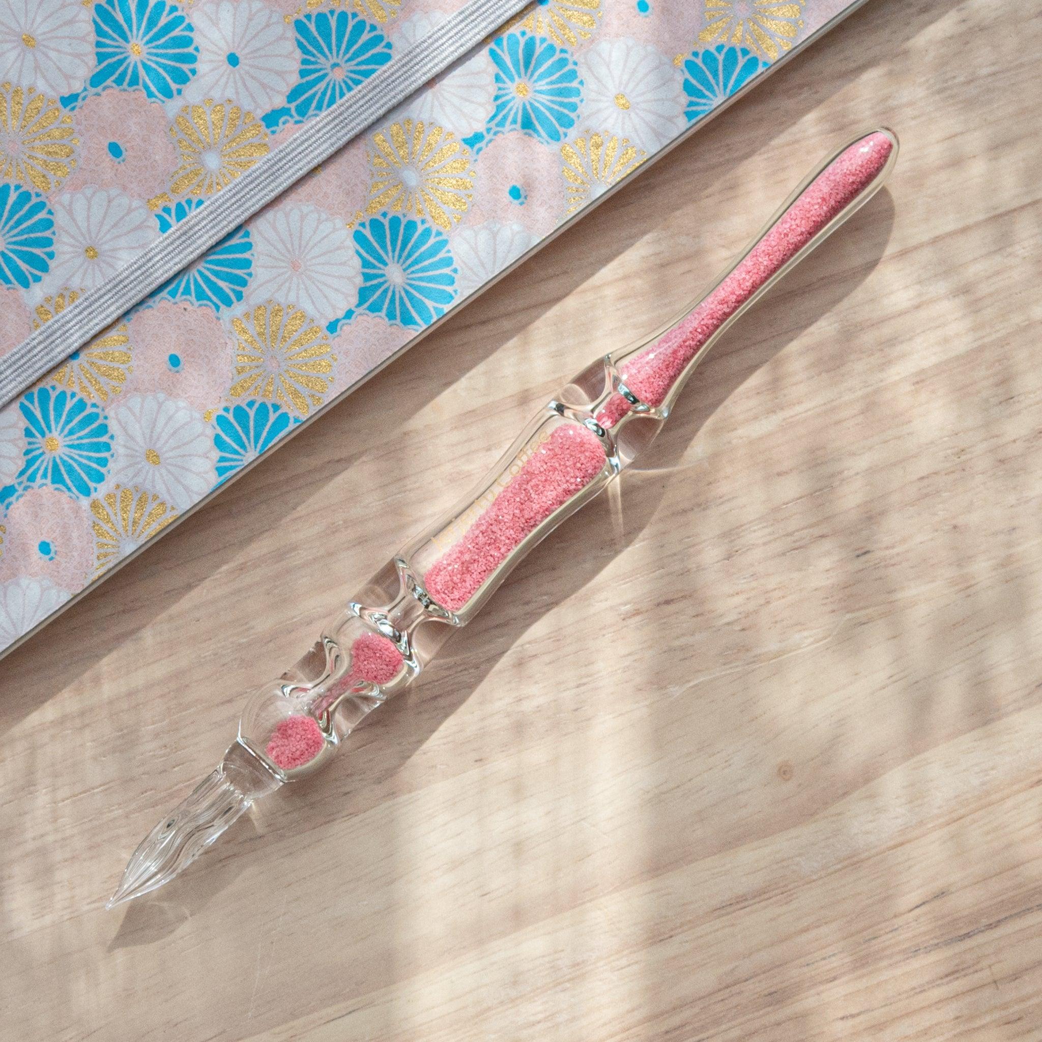 Sakura Hourglass Glass Dip Pen with matching pink cherry blossom-themed ink cartridge and decorative blossom notepad