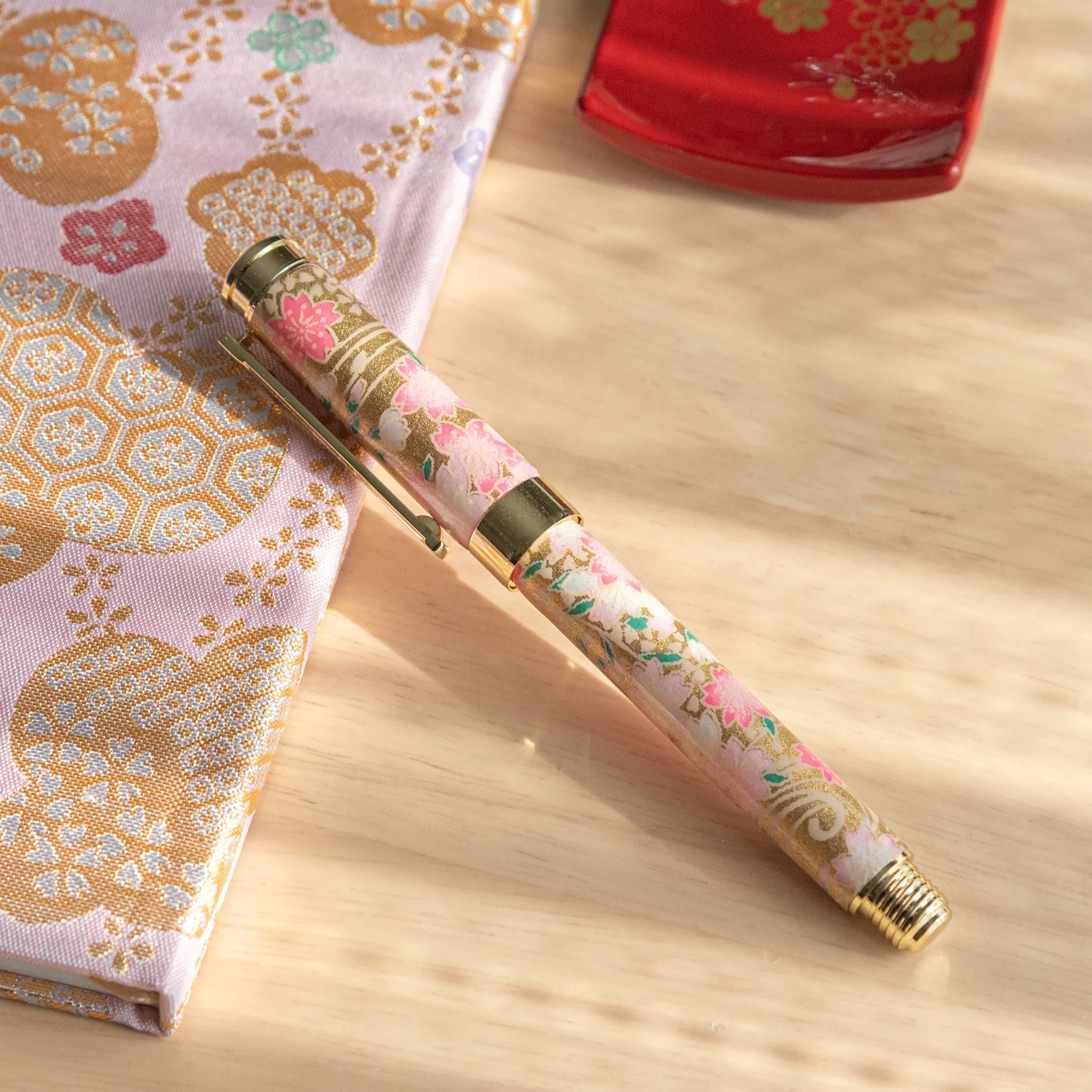 Japanese fountain pen with cream and pink Mino washi featuring pink cherry blossoms and gold geometric pattern
