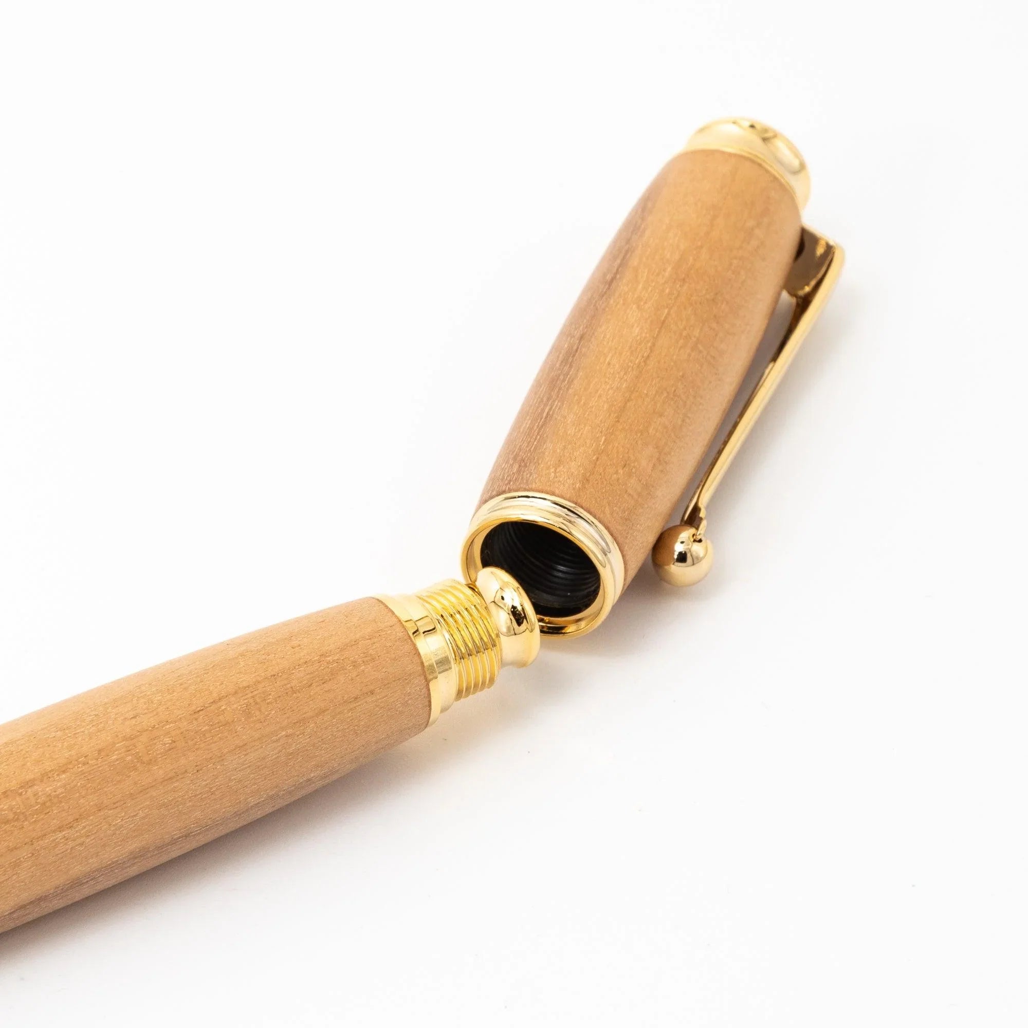 Close-up of wood fountain pen screw cap joint showing gold threading, trim rings, and ball-end clip on white background