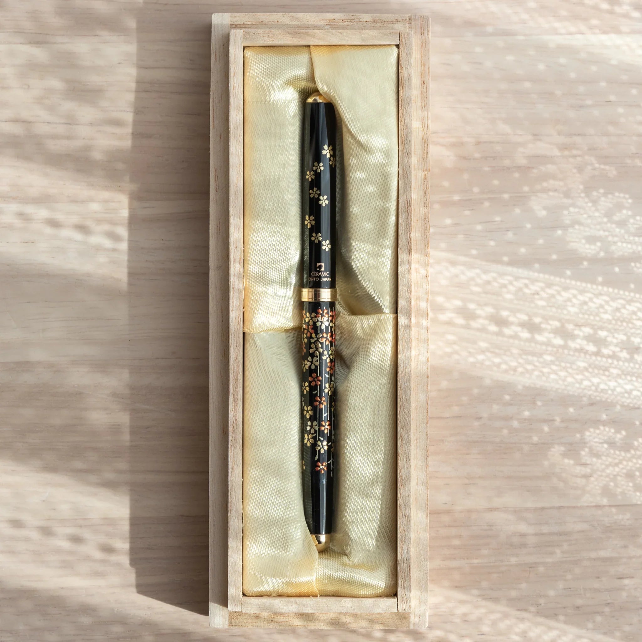 Yamanaka lacquered ballpoint pen displays delicate cherry blossoms and tree branch composition for writing