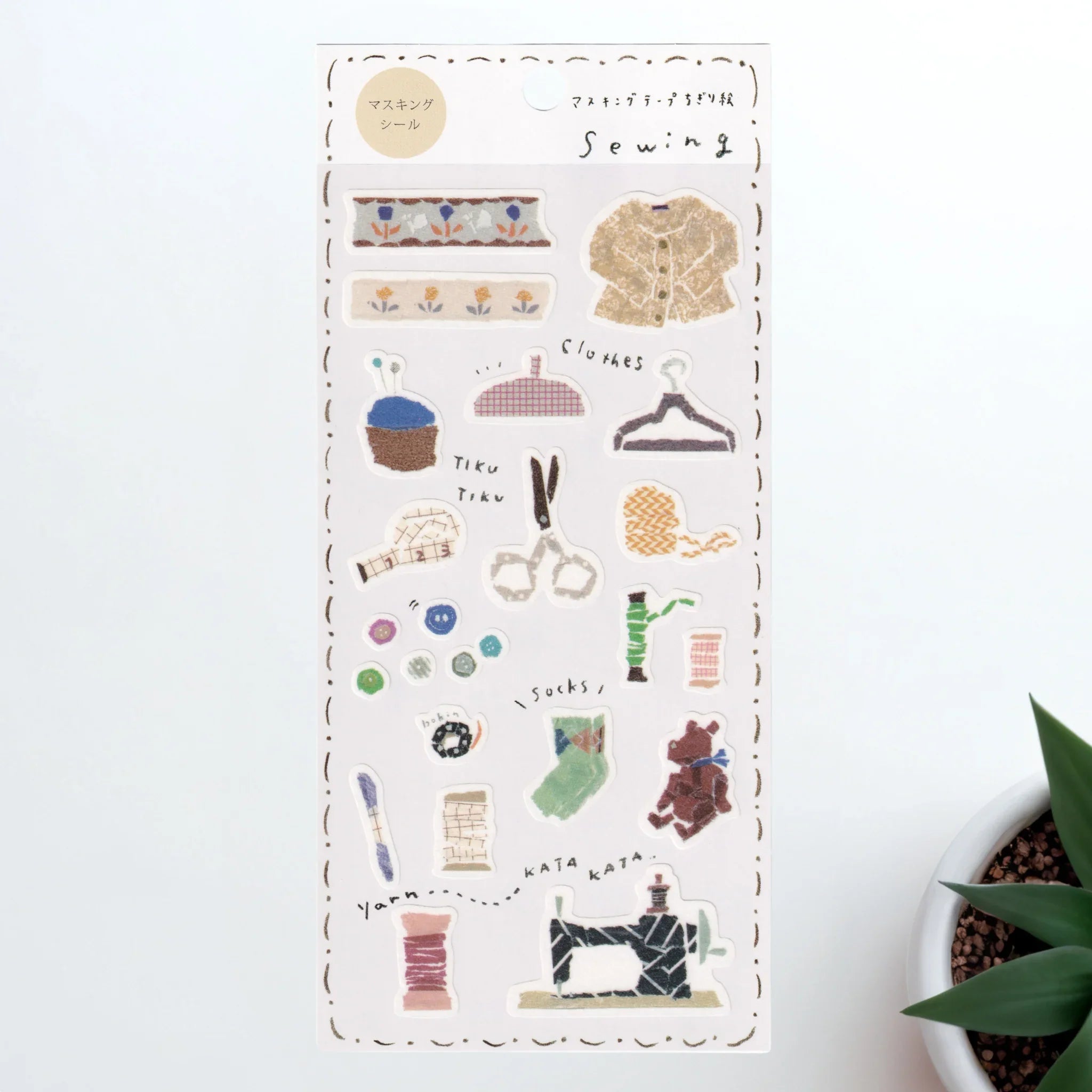Iyo washi sticker sheet showing sewing items with fabric patterns, buttons, clothing hanger and sewing machine on white