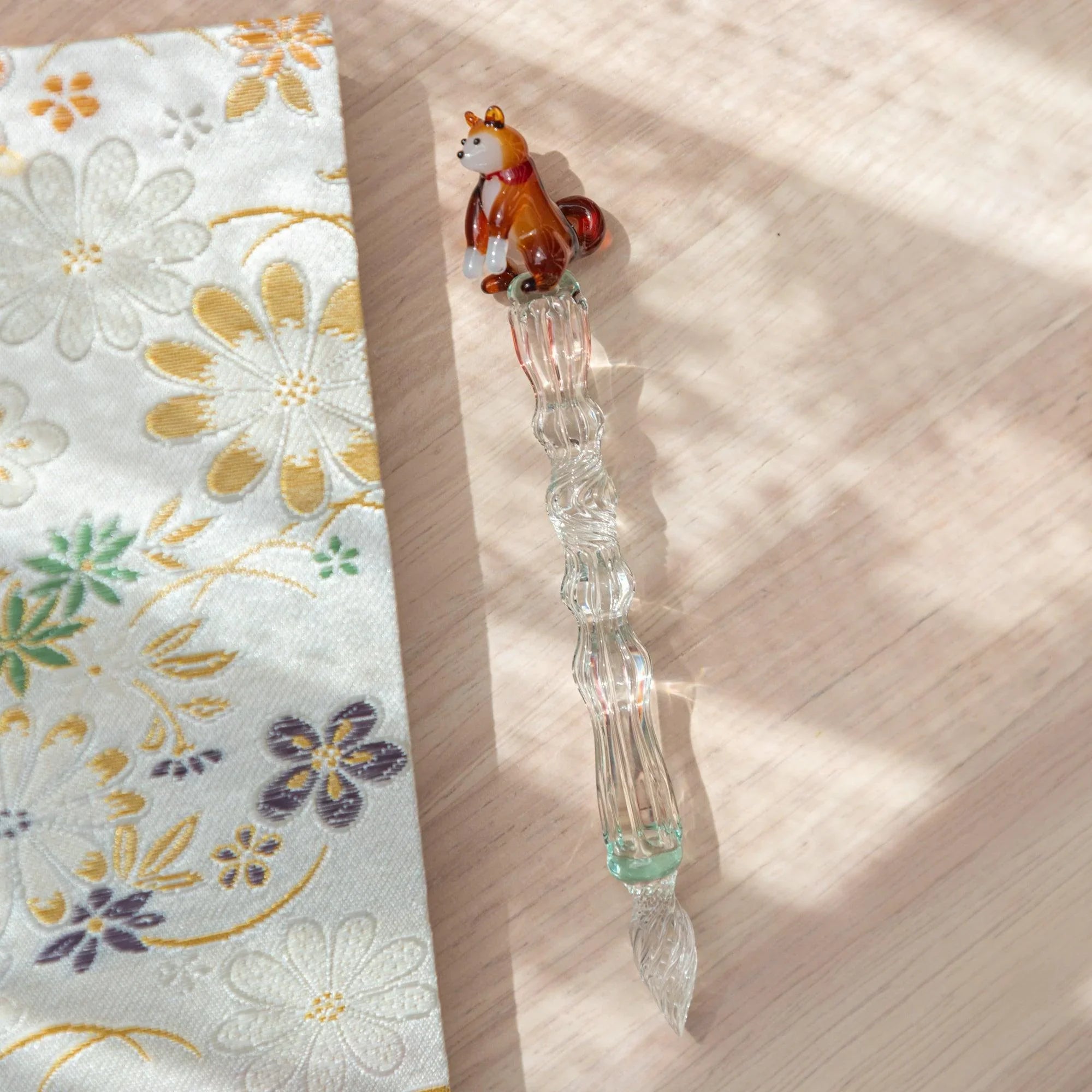Japanese glass dip pen featuring reddish-brown ceramic Shiba Inu dog topper on clear ribbed textured glass barrel