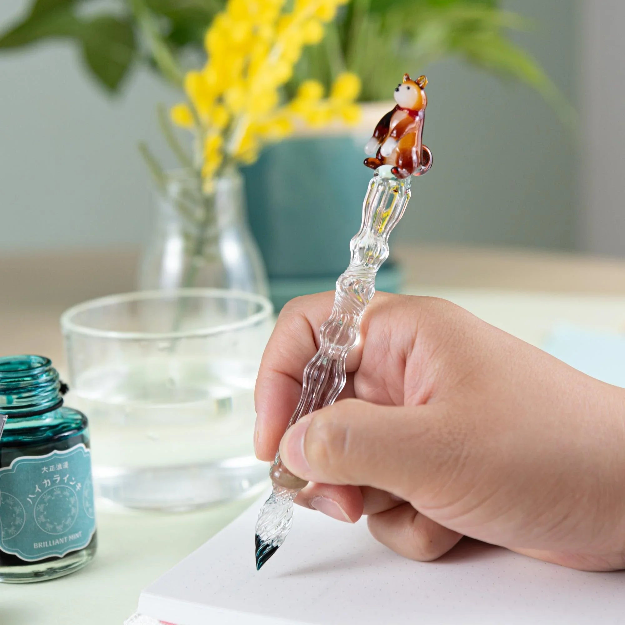 Japanese Shiba Inu glass dip pen with textured ribbed barrel and detailed ceramic dog figurine topper, close-up detail