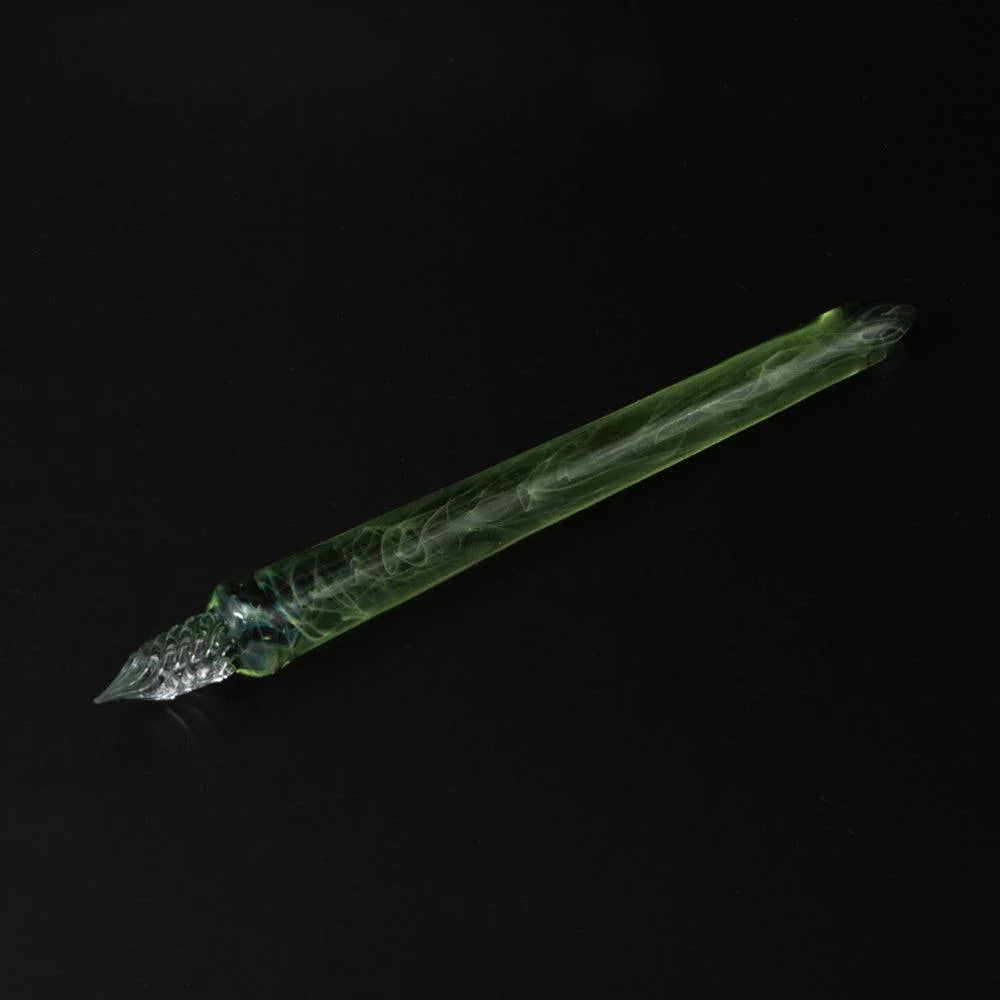 Full green-grey swirled glass dip pen on black background angled view showing internal smoke patterns