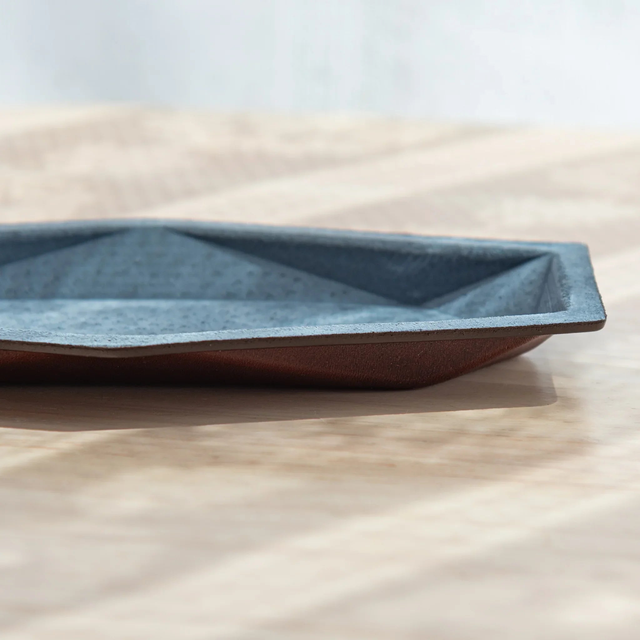Hexagonal slim pen tray side view showing pink leather exterior and blue-gray suede interior with faceted edges