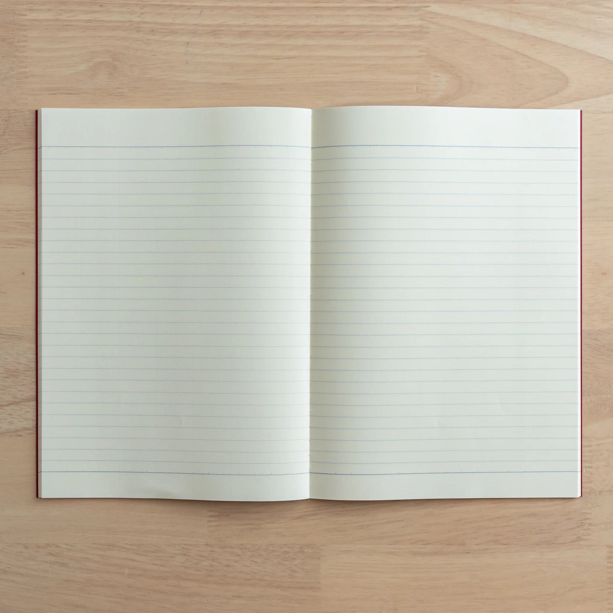 Tsubame Fools Cream Notebook spread displaying cream-colored thick ruled pages and red binding flat lay composition