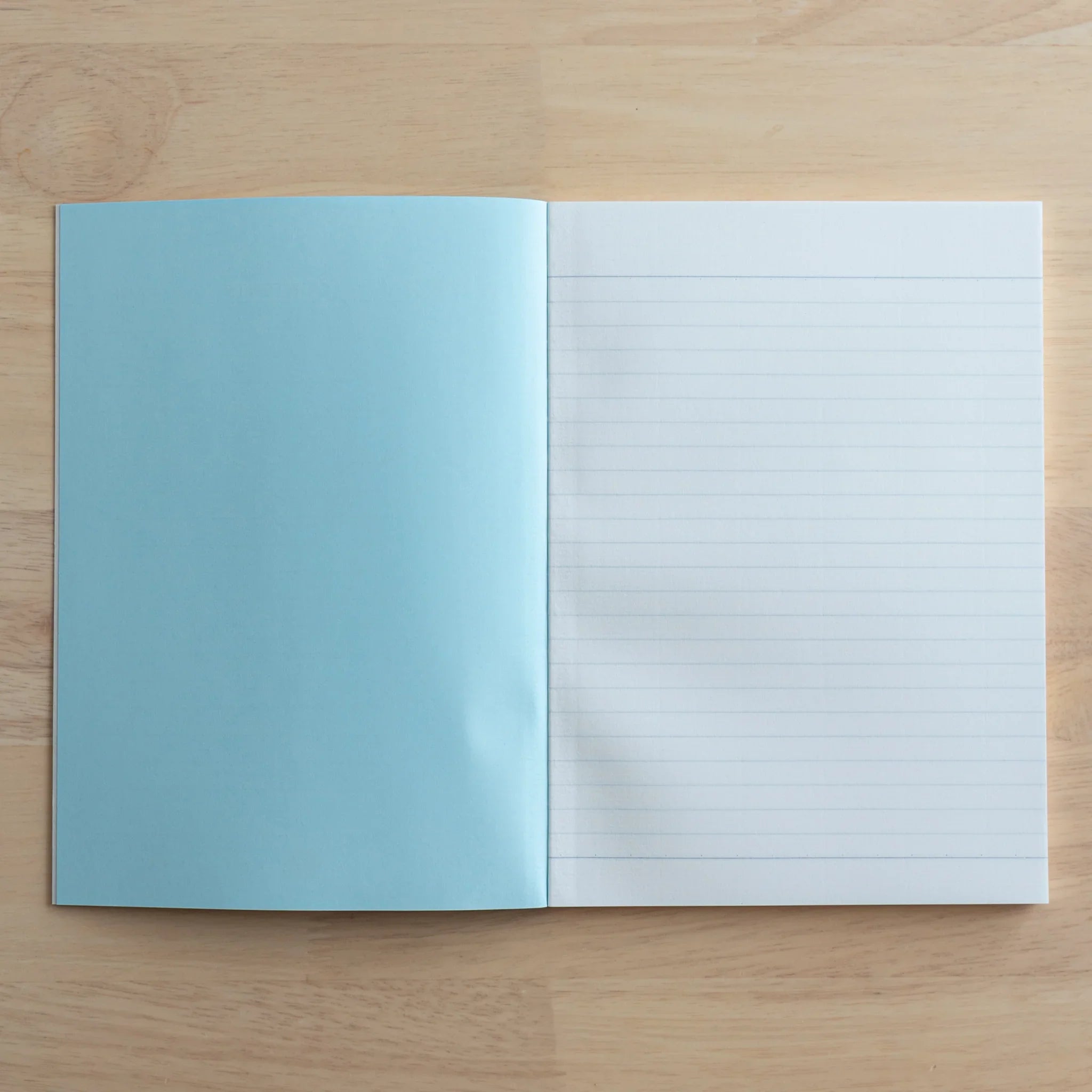 Tsubame Fools University Notebook opened displaying turquoise back cover and white ruled interior pages