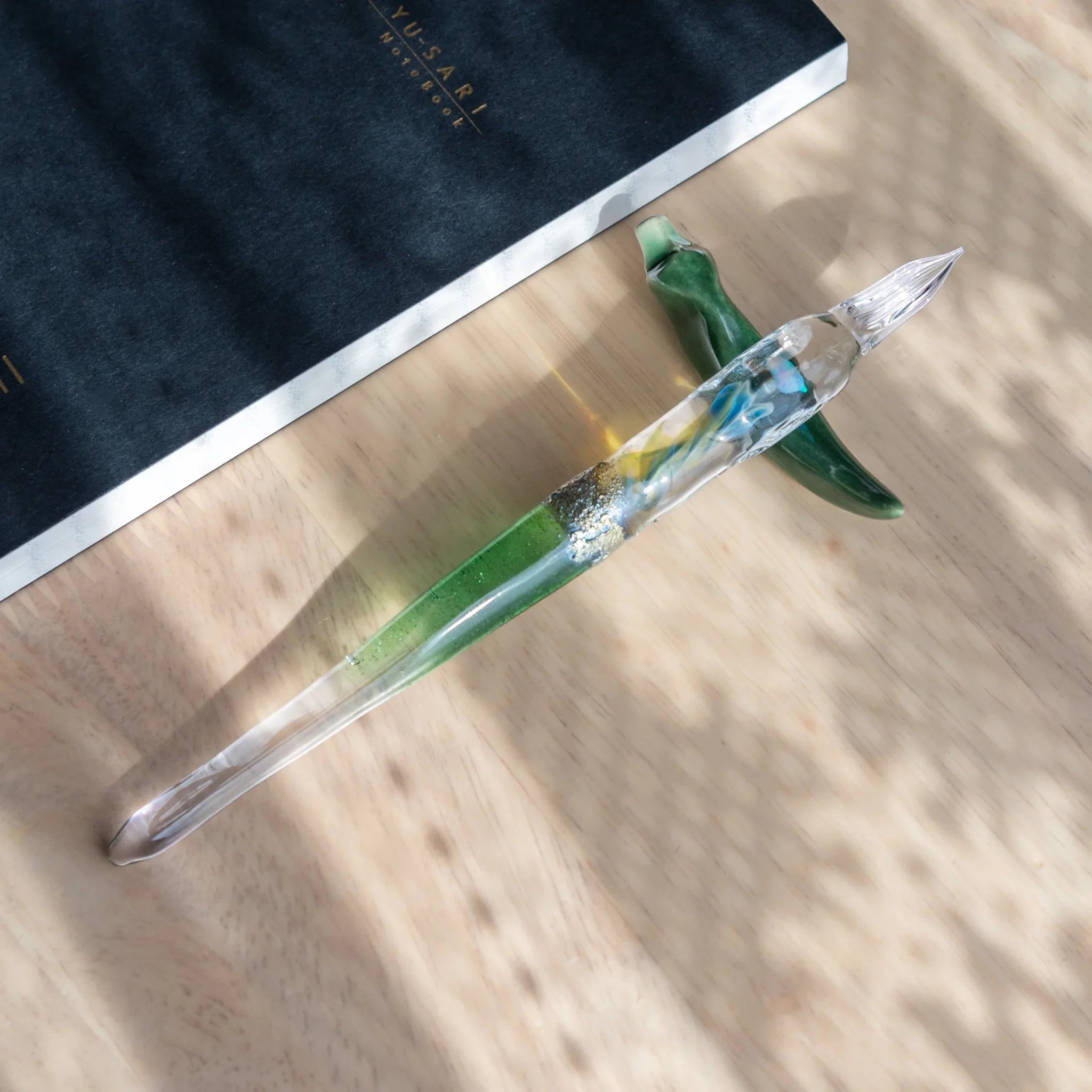 Green Tsukuyomi glass dip pen photographed to display distinctive twisted nib with hand-made design detail shine