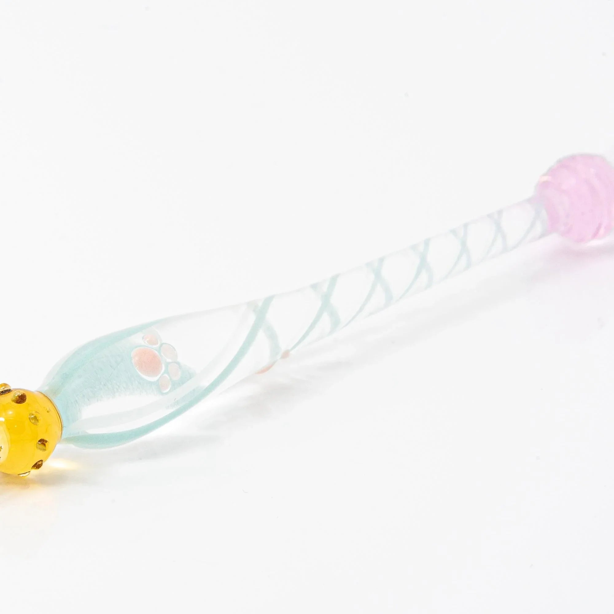 White Nyanko sitting cat on clear transparent spiral-etched glass dip pen handle in detailed closeup