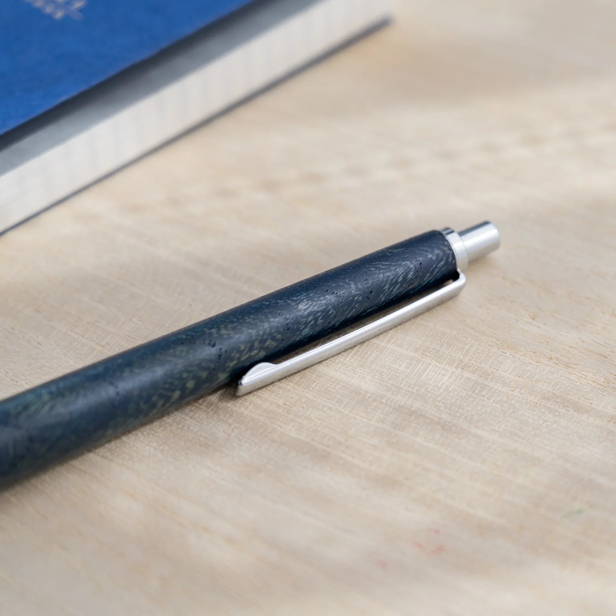 Indigo blue zelkova wood urushi mechanical pencil, close-up of knock end and silver clip, Japanese keyaki wood